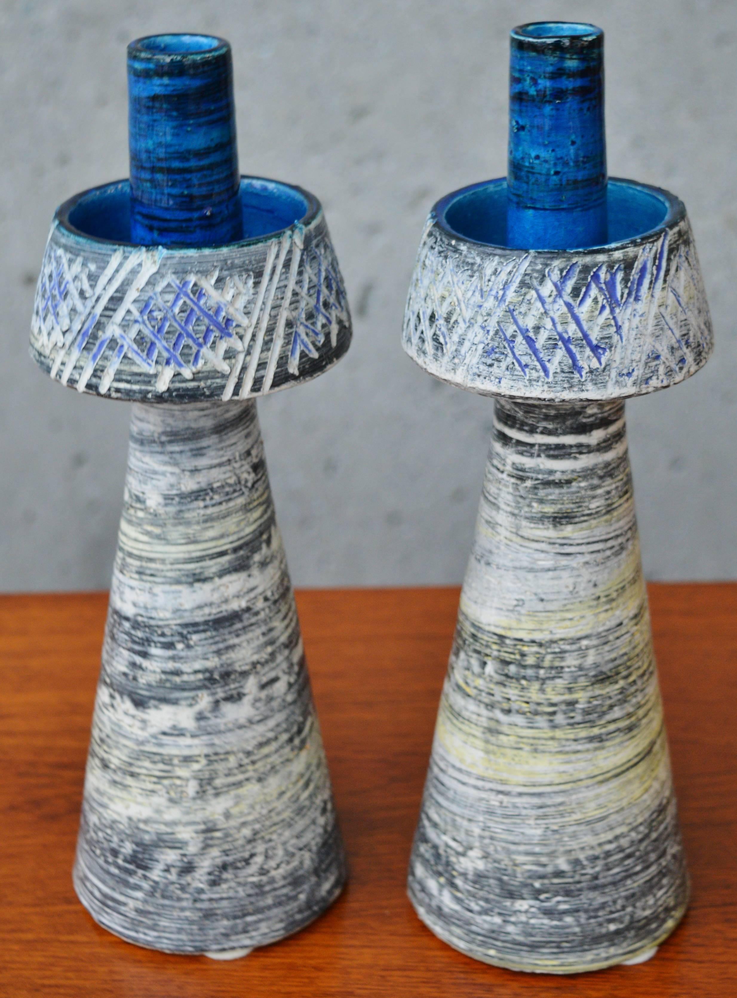 This lovely pair of Mid-Century Modern Italian ceramic candle sticks are a rare Aldo Londi for Bitossi find. Featuring conical bases that taper towards the top and are glazed in diagonal striations of gray and yelllow on white, which then flares