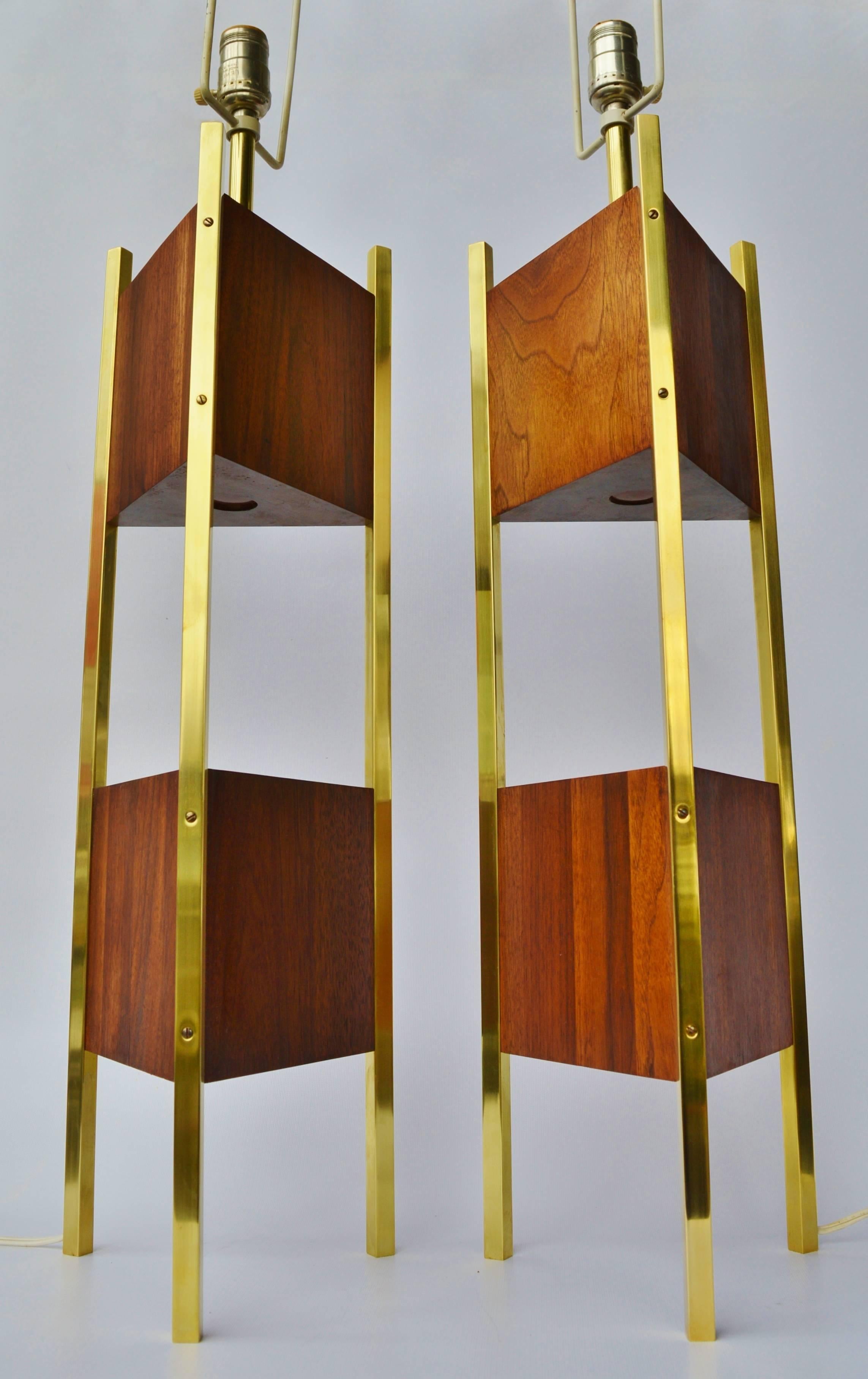 This striking pair of Mid-Century Modern lamps are dramatic in both size and in airiness. Featuring two solid walnut triangular sections floating between square brass rods and signature Laurel harps. In excellent condition with newly polished brass