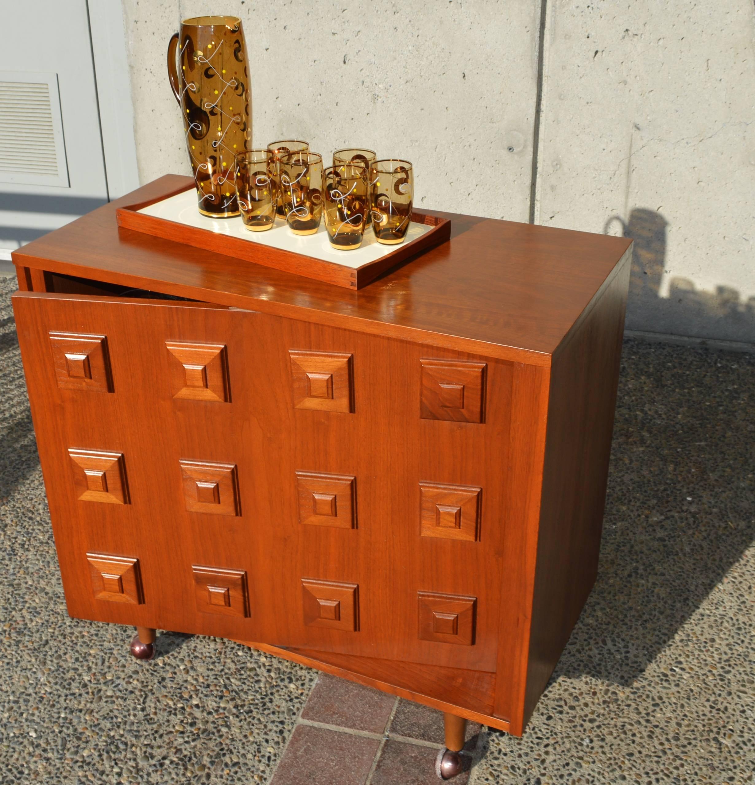 This Mid-Century Modern walnut bar is Mad Men-tastic! Featuring a stunning stacked squares molding detail on the door front, which swivels open to reveal two half moon shelves with laminate bases (so your liquor bottles won't stain them!) and a