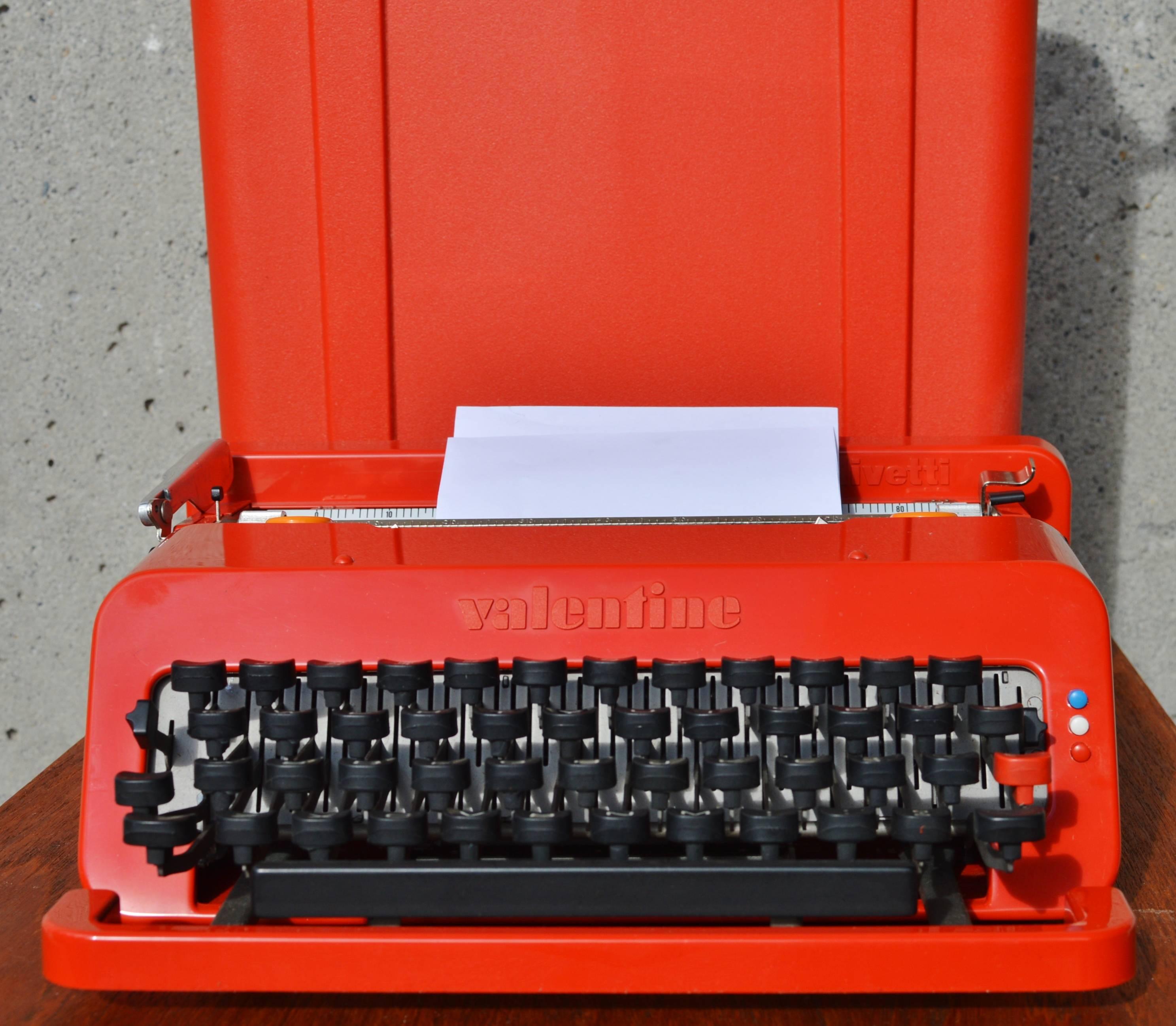 This super collectable and fun bright red Olivetti Valentine typewriter was designed by Ettore Sottsass (Italy) in the 1960s. Note how the back of the typewriter becomes the lid for the carrying case with black rubber clasps. Fully functional, the
