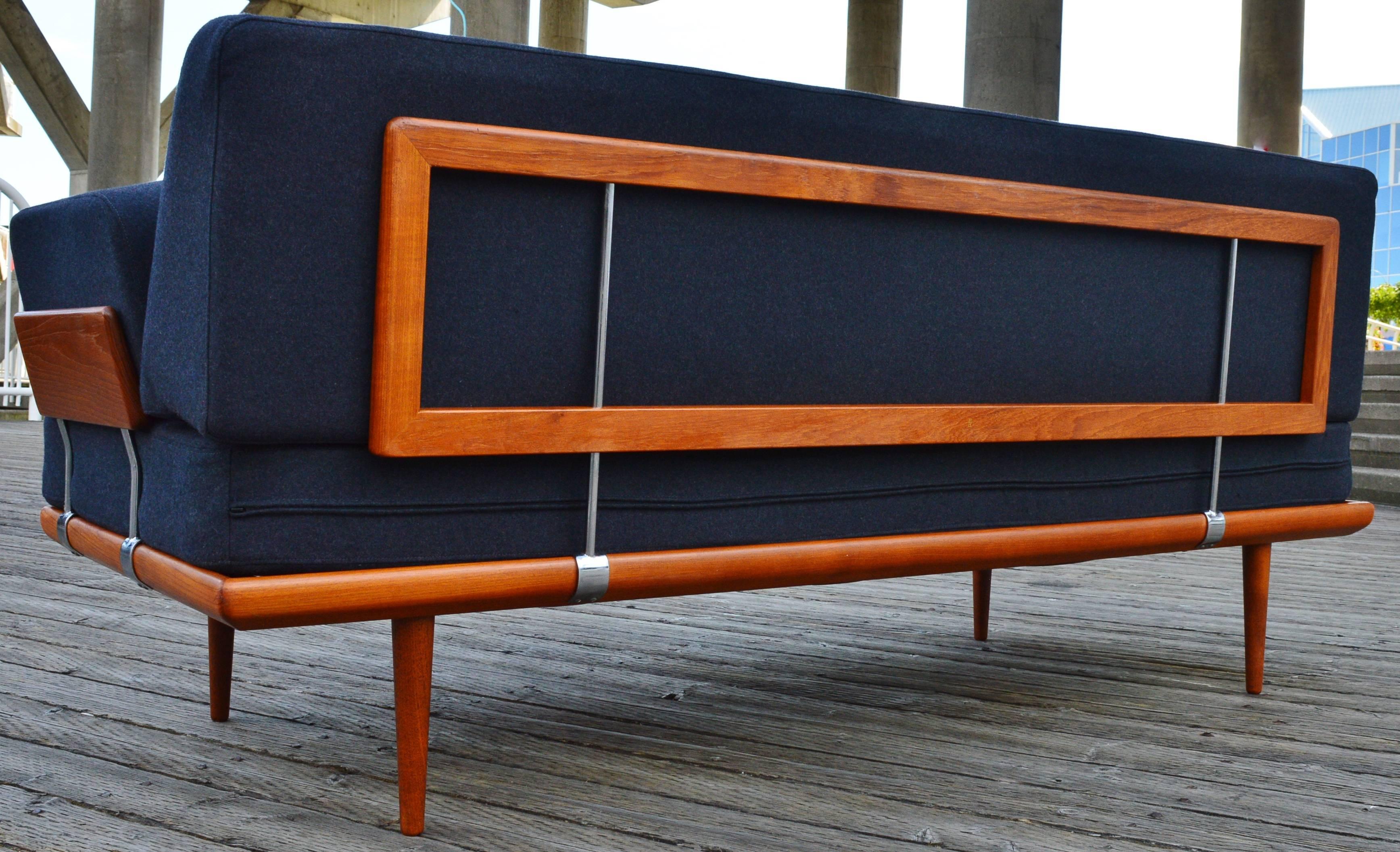 This striking Danish modern teak Minerva daybed was designed by Peter Hvidt & Orla Mølgaard-Nielsen for France & Sons and is the rare version with the teak armrests, as well as the original coil spring inserts in all the cushions that makes for