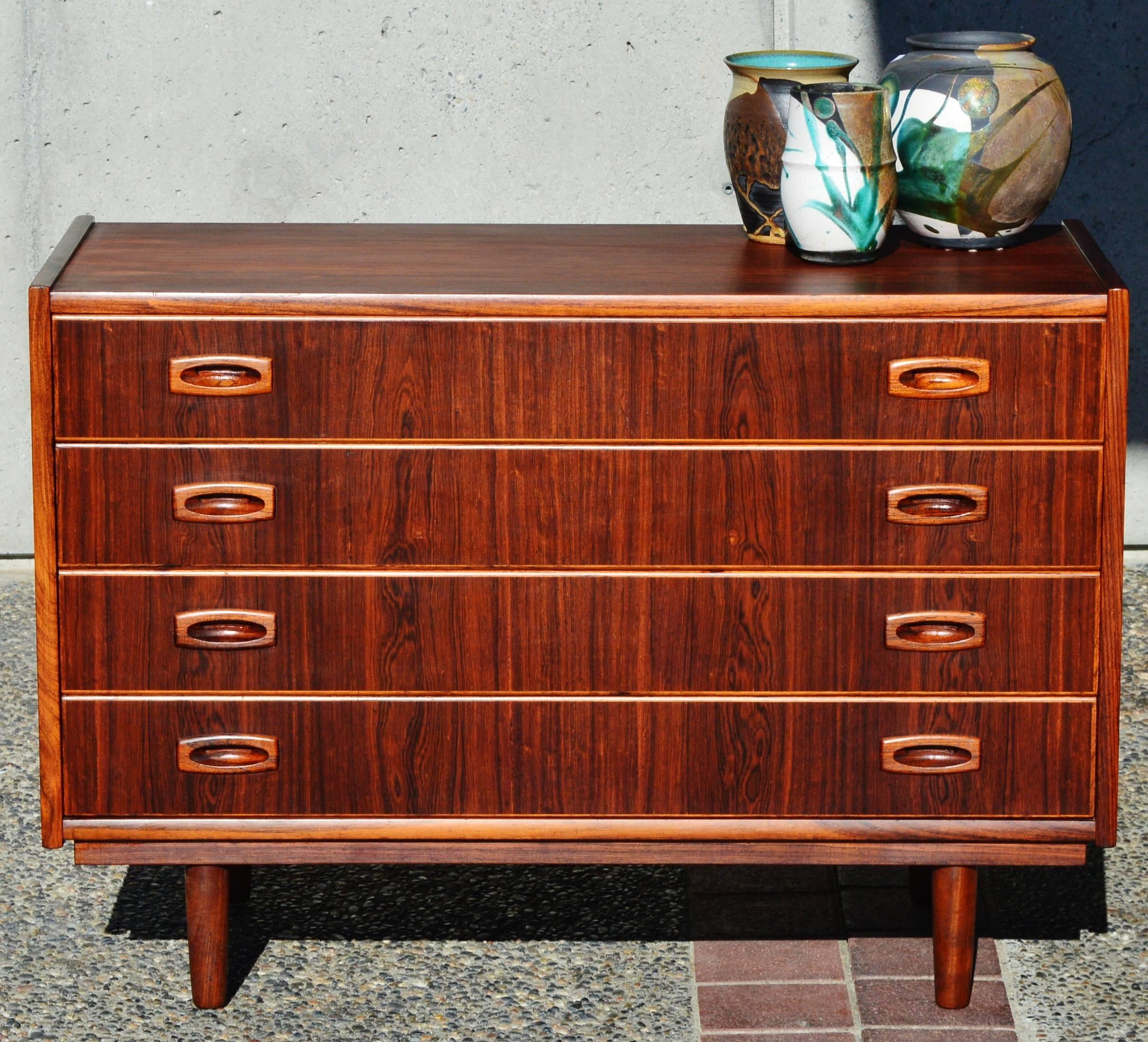 This impeccable Danish modern rosewood four-drawer chest or dresser is a top quality design by Dammand & Rasmussen, acclaimed Danish craftsmen. Featuring all hardwood construction, with birch drawer frame construction and dove tail joins. Note the