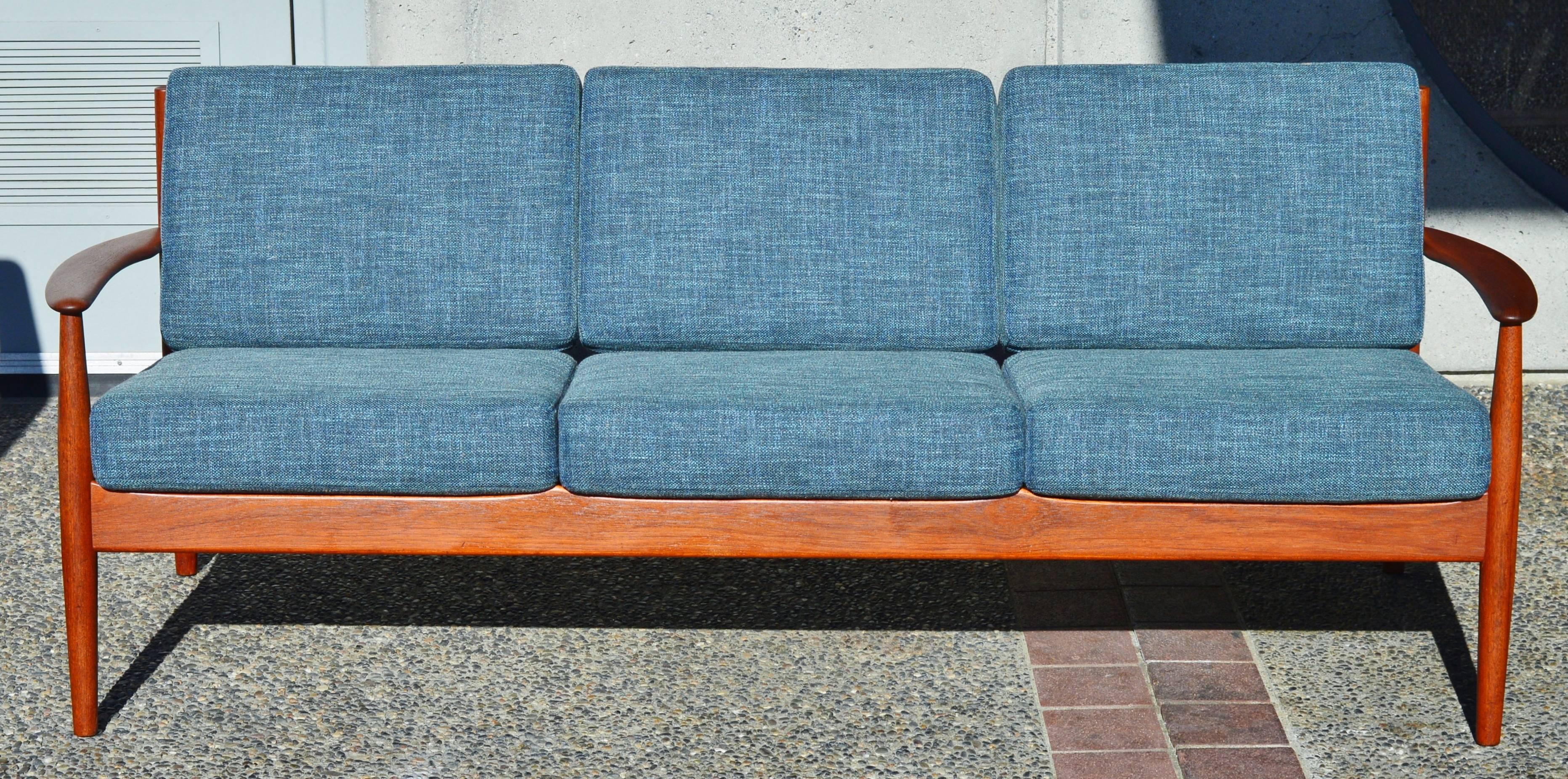 This spectacular Danish modern teak frame sofa is a gorgeous sculptural beauty by Grete Jalk for France & Sons. Featuring lovely flared armrests, super comfortable lumbar support with the contoured back slats, and contouring between the cushions