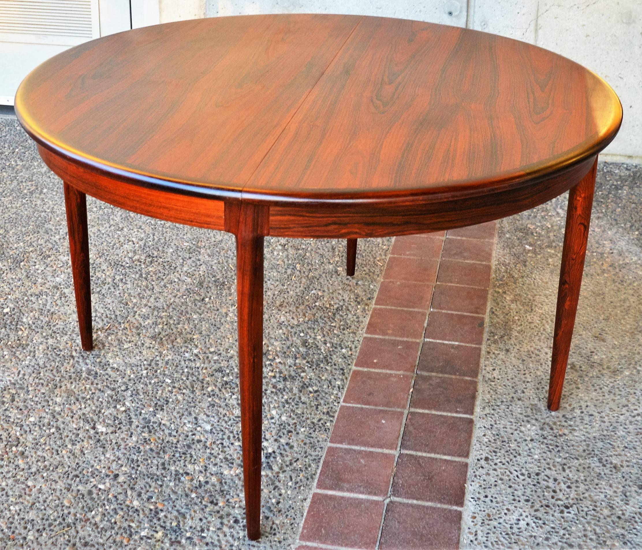 This impeccable Danish modern rosewood dining set was entirely designed by N.O. Moller and bears the Danish quality control symbol as well as the Maker's Marks/Medallions. The dining table is a very unique one that was minimally produced in