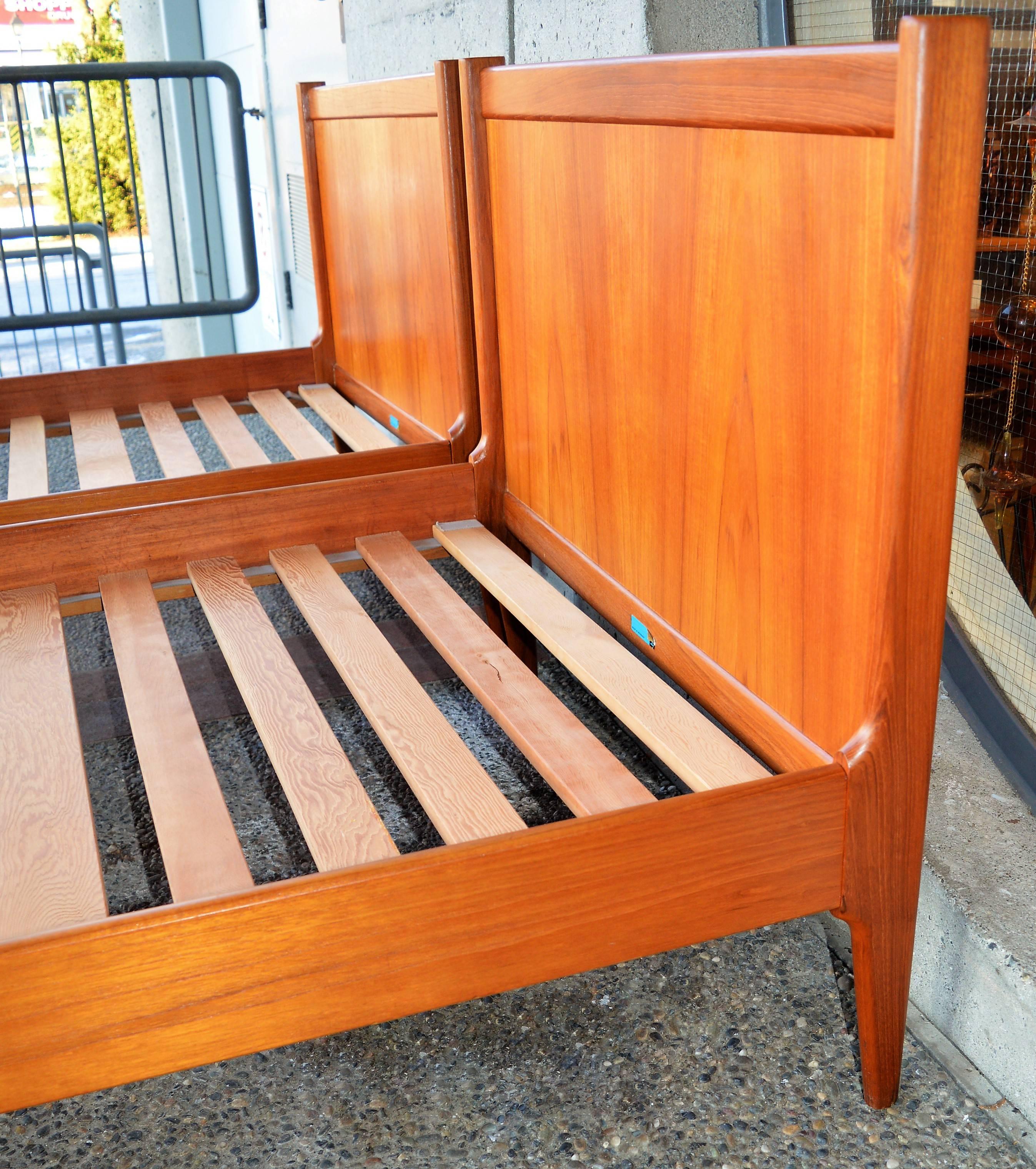 This lovely pair of quality Danish Modern teak twin sized bed frames were made by Dyrlund in the 1960s and disassemble for easy transport, using quality heavy metal toothed connectors and steel plates. Note the sculptural detailing around the side