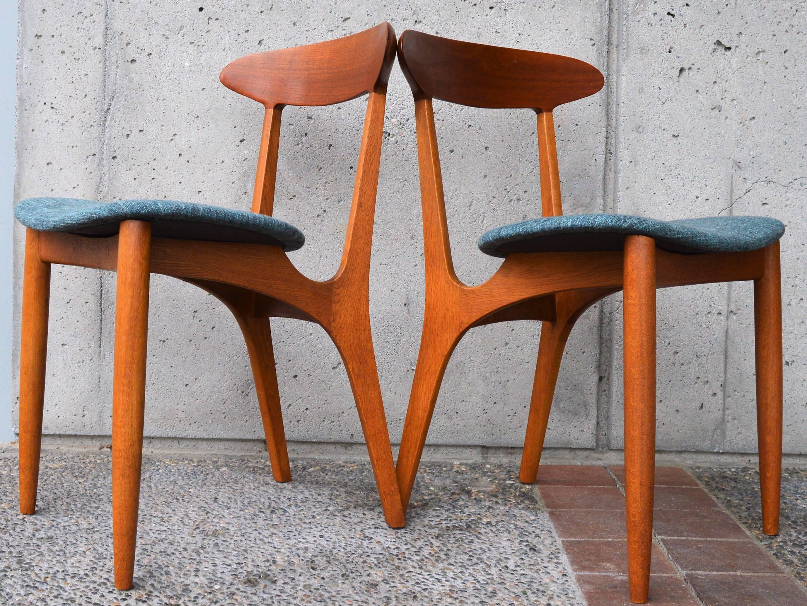 This stellar and rare set of four Danish modern solid teak and oak dining chairs are a high end construction by Kurt Ostervig. I love the contouring throughout the chair, from the way the frame dips down below the back of the seat with it's splayed
