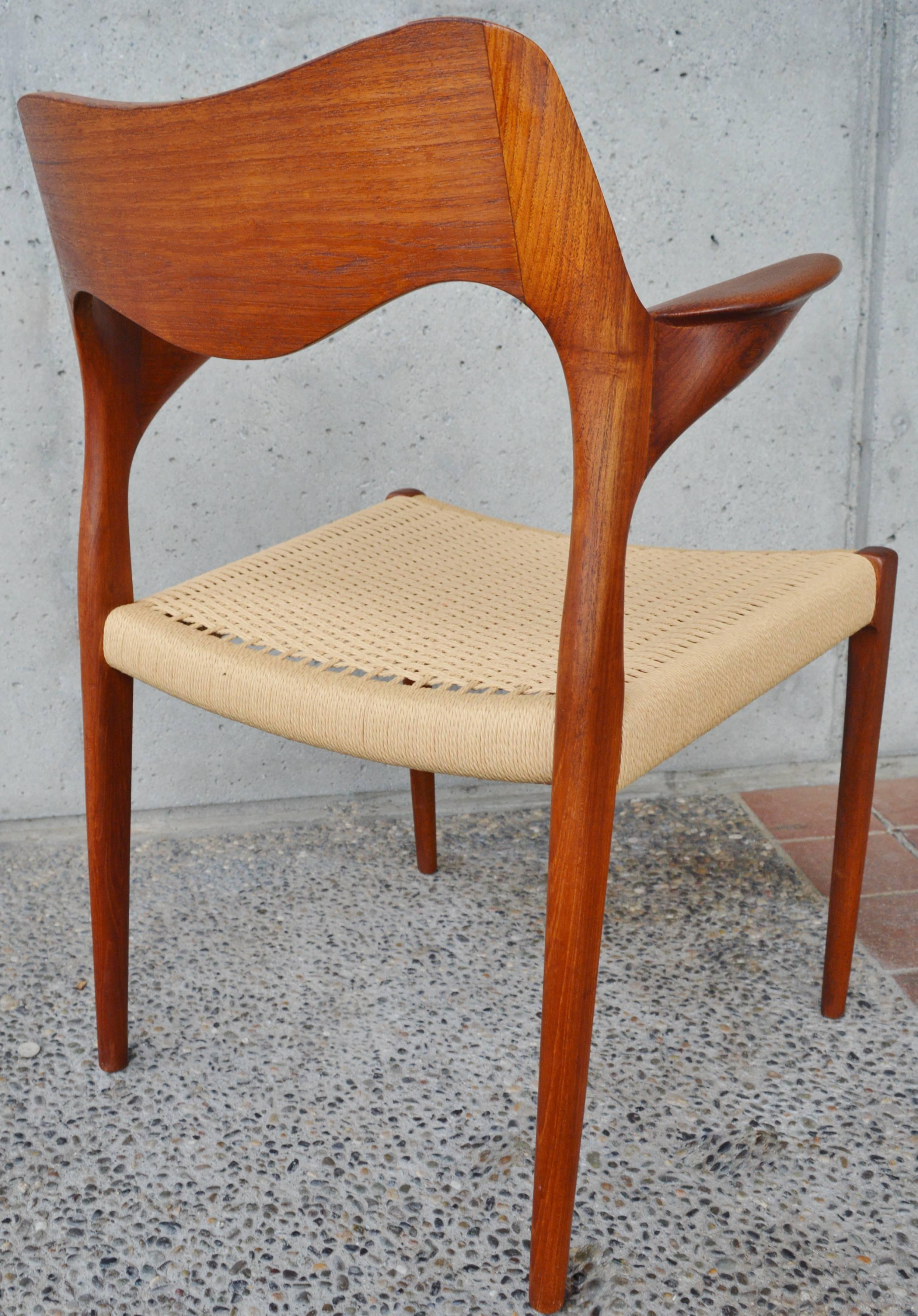 This wonderful Danish Modern teak armchair by NO Moller has such delightfully sculpted armrests. Perfect to complete your dining set or use as a desk or occasional chair. Featuring a newly woven papercord seat and in fantastic condition.