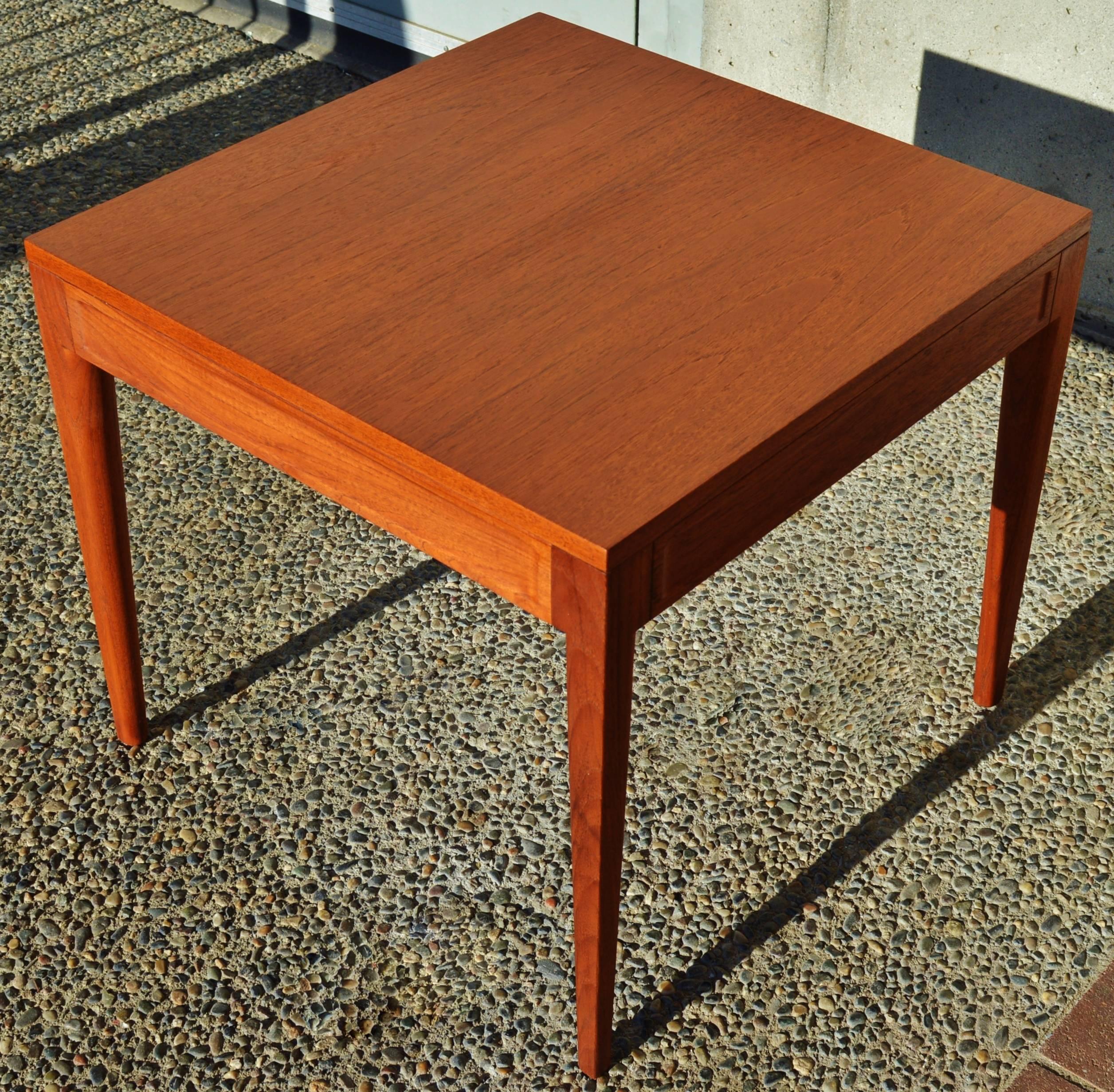 This gorgeous Danish modern teak side or small coffee table was designed by Finn Juhl for France & Son in the 1960s and bears the metal medallion with the maker's mark underneath. The contoured cut-aways carved out of the solid teak side panels