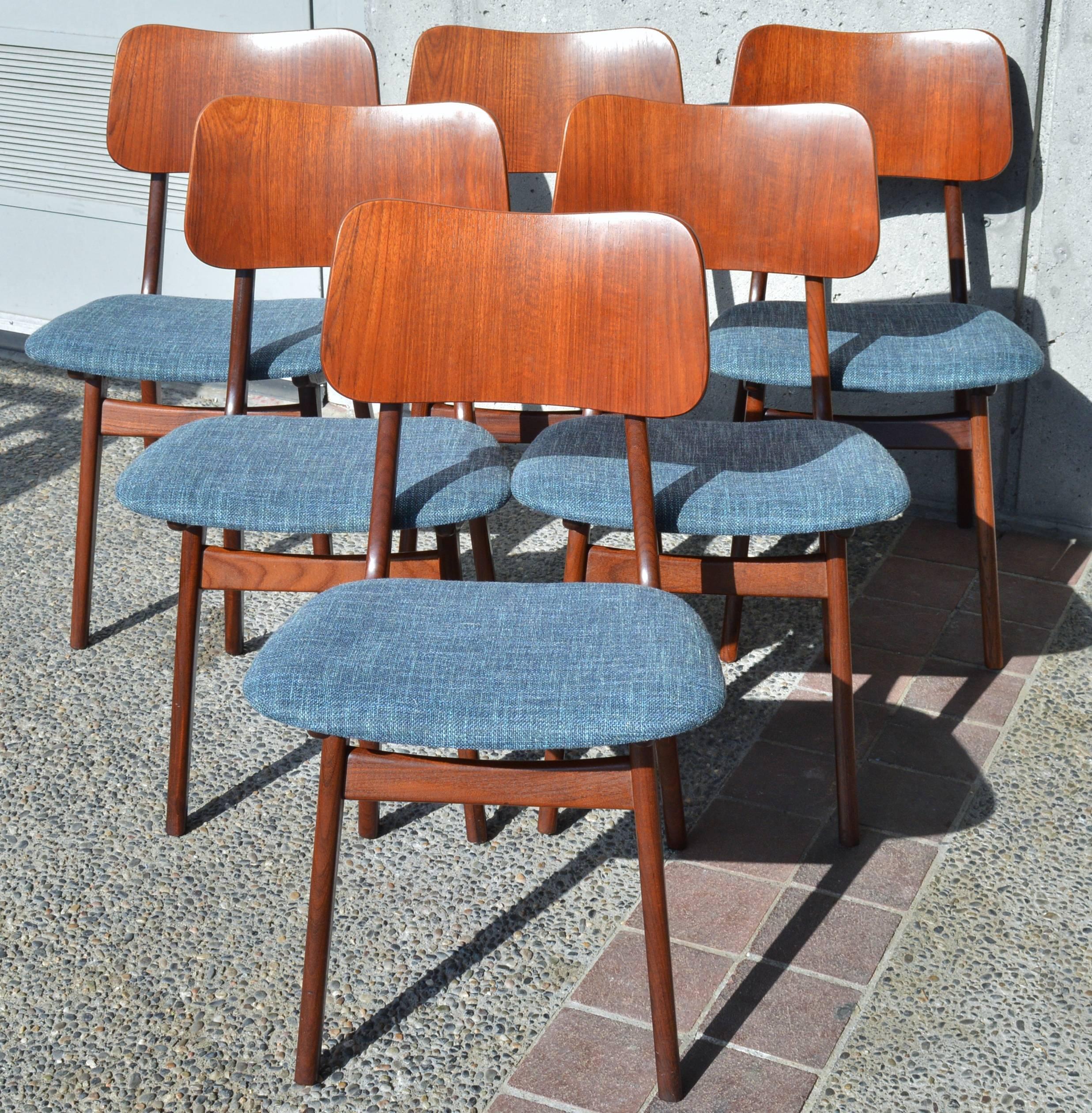 This lovely set of Danish modern teak shield-back dining chairs were designed by Arne Hovmand-Olsen and are the rare version with the all wood back (normally the front of the backrest is upholstered.) Note the floating backrest that is spaced by
