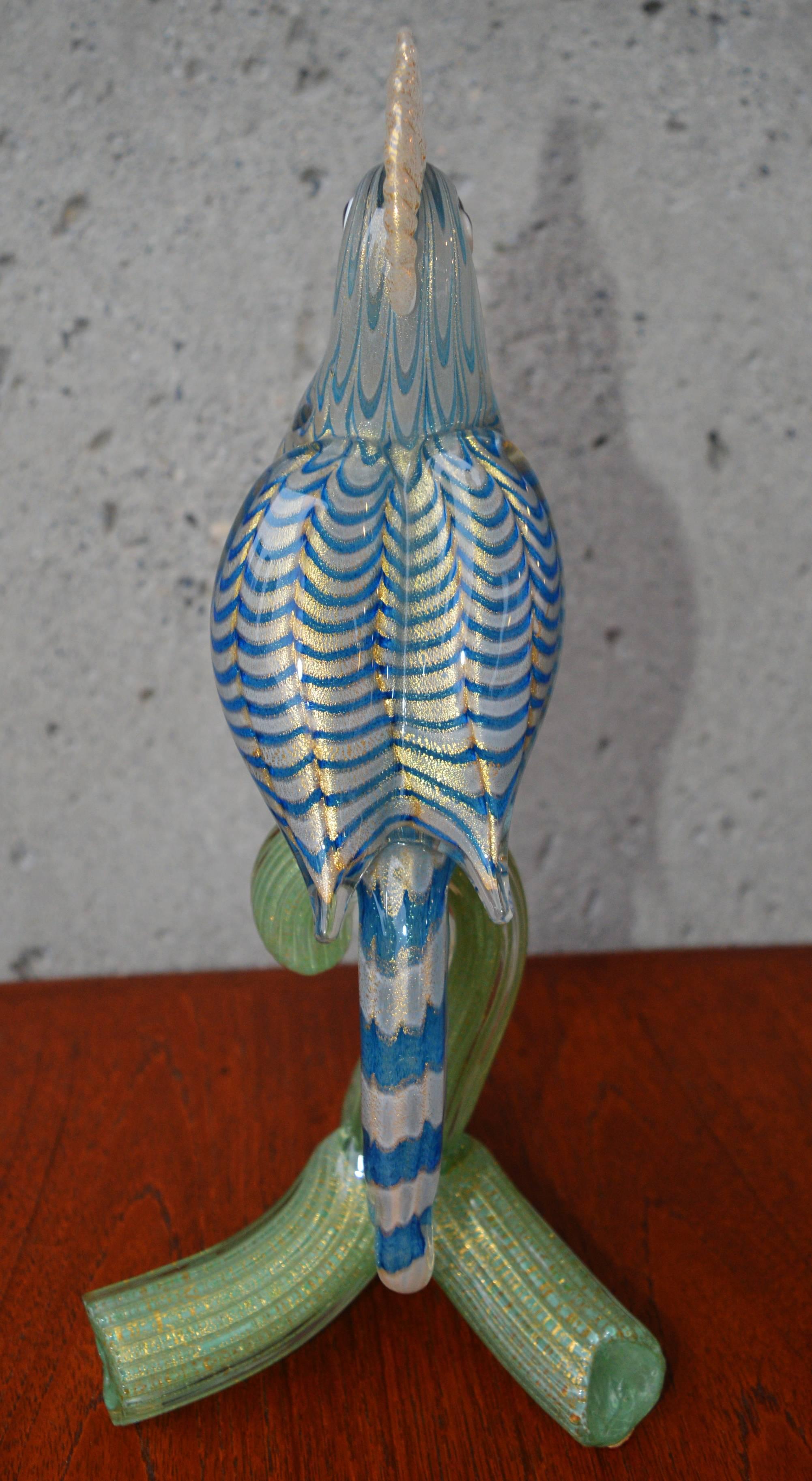 This incredibly striking large-scale handblown art glass parrot figurine has impeccable detailing throughout. The waved pattern of blue and gold in the feathers is very realistic, and the green and gold base a perfect contrast. In fabulous condition