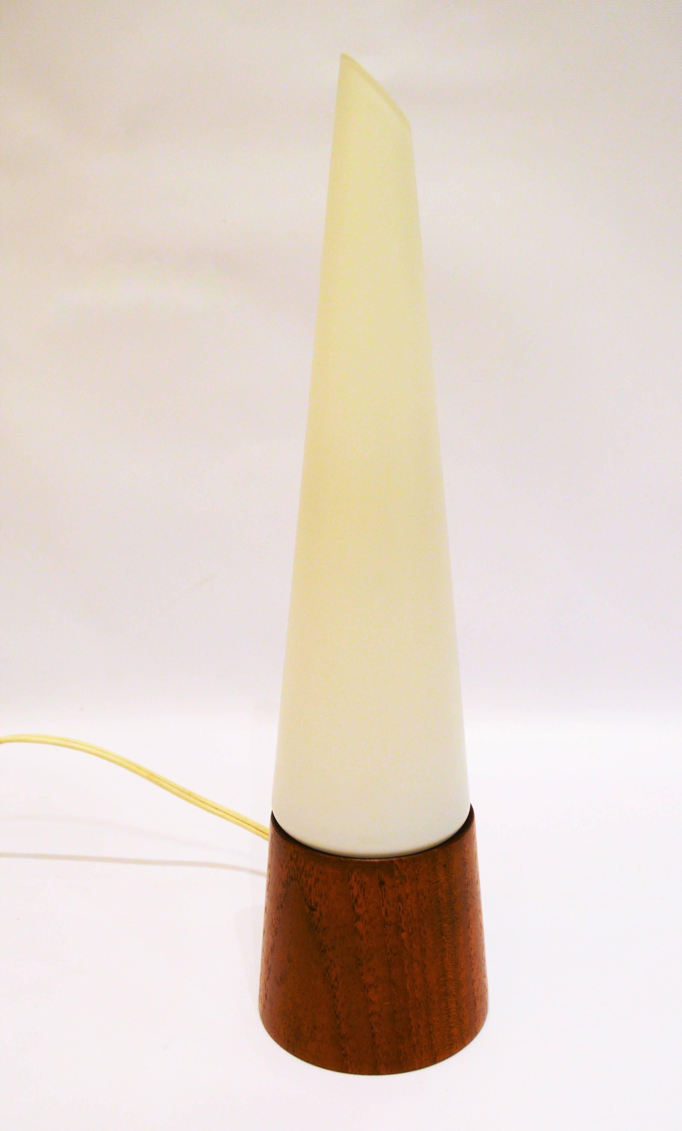 This delightful Atomic influenced conical teak and frosted white glass lamp may be small but packs a big bang for it's size. Likely designed by Holm Sorensen in terms of design, though I couldn't find another like it on line. The base is teak and