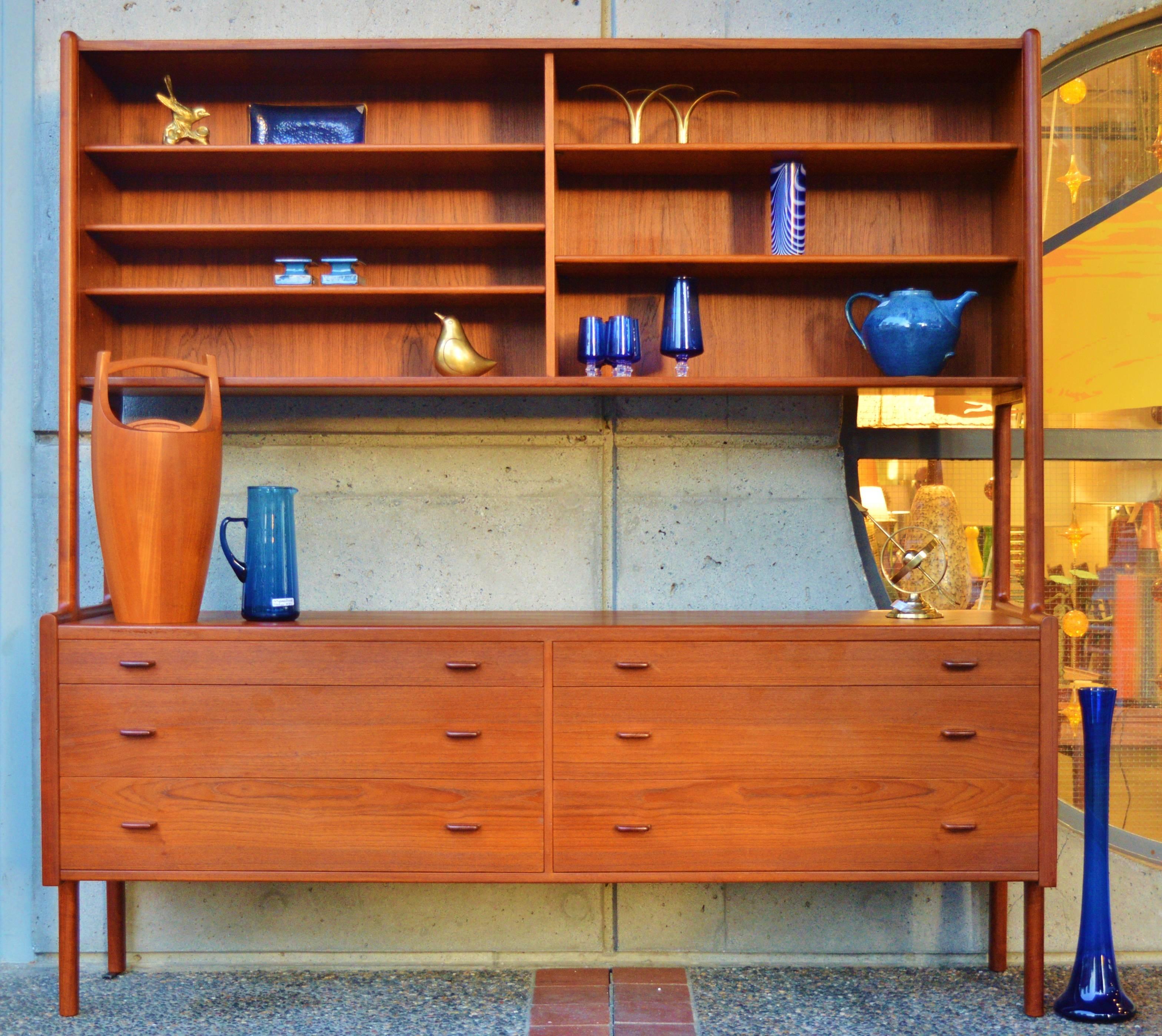 This impeccably designed and constructed early Danish modern teak credenza with floating hutch was designed by Hans Wegner in 1956, for Ry Mobler. This is the model with the glass sliders on the upper section, making it visually much lighter and