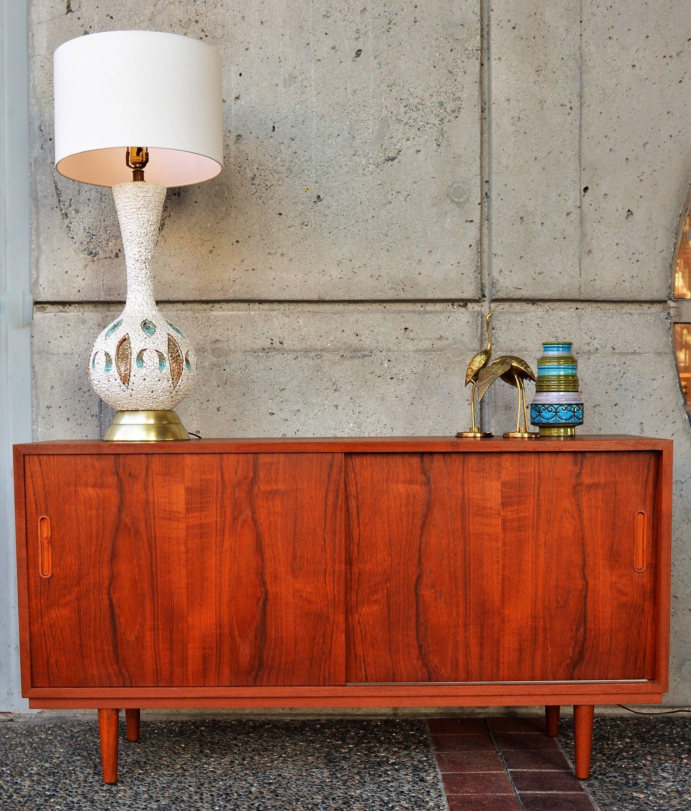 This lovely Danish modern teak buffet or credenza with smaller proportions is all wood construction from the, 1960s. Featuring a birch interior, nice and light in contrast to the rich patina of the body, the interior features three adjustable