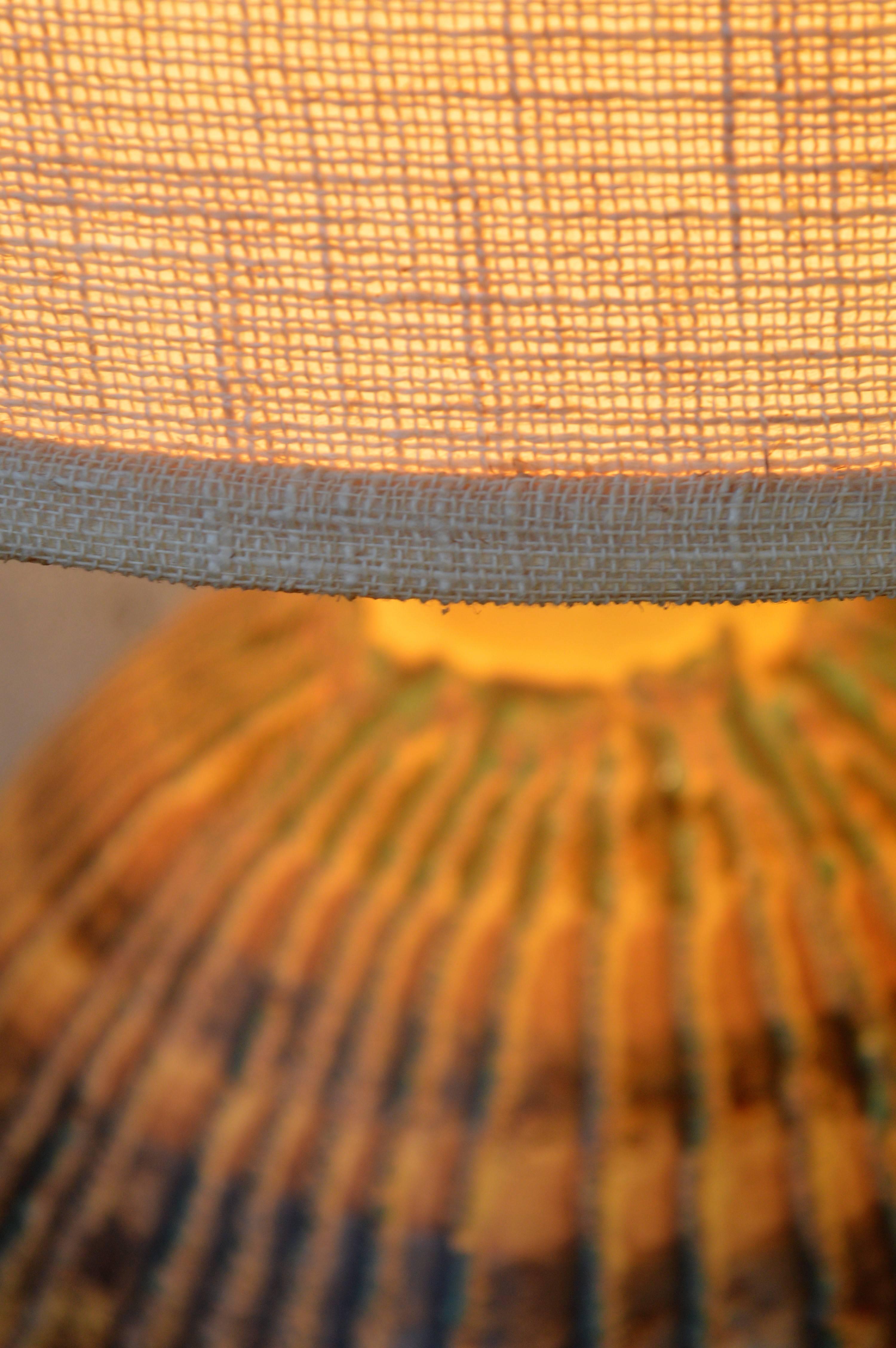This large impact ceramic lamp has amazing glazing in earth tones with pops of turquoise. The original coordinating shade has matching colored trim. In excellent vintage condition. Wired for North American standards with a two prong plug. Holds a