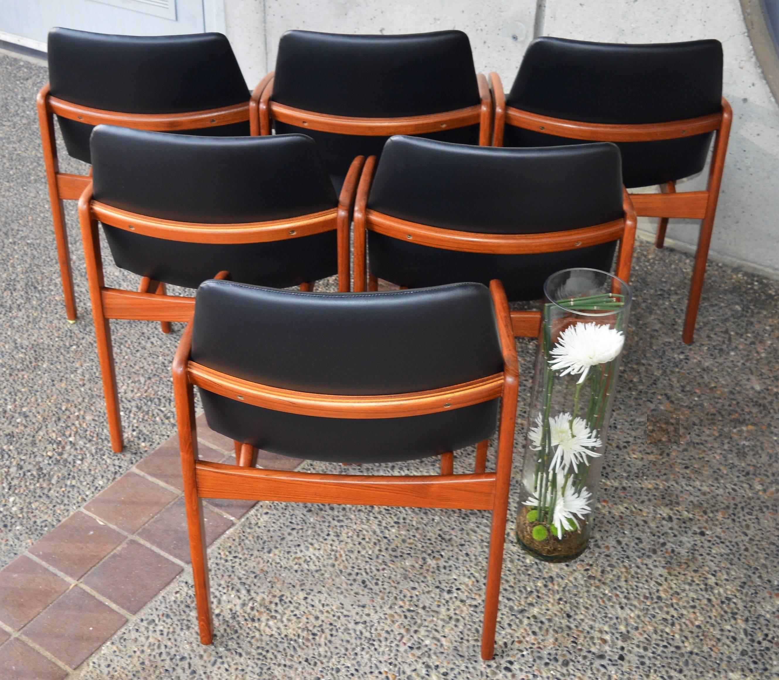 This elegant set of six Danish modern teak dining chairs were designed by Kai Kristiansen in the 1960s and featured angled armrests that slope gently downward. This makes them ideal for any dining table or conference table, as the standard arms on