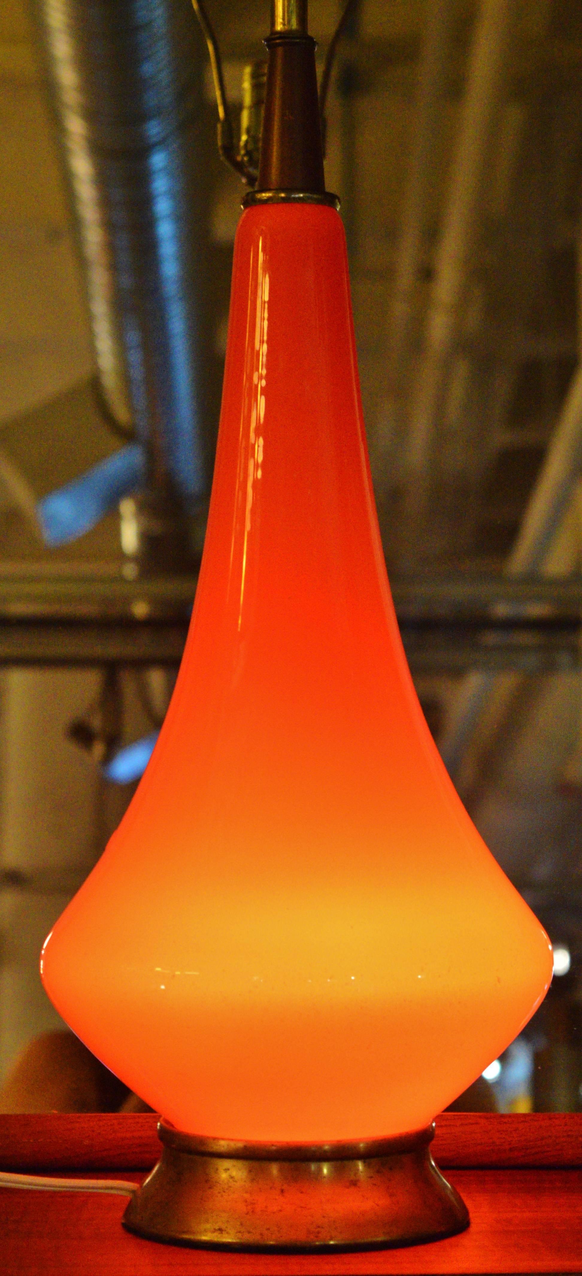 This Italian orange glass lamp has the most striking color and form. Featuring an awesome light in the base (see second photo) as well as above--the last two photos attempt to show the distinction of the base light on and off though they do it no