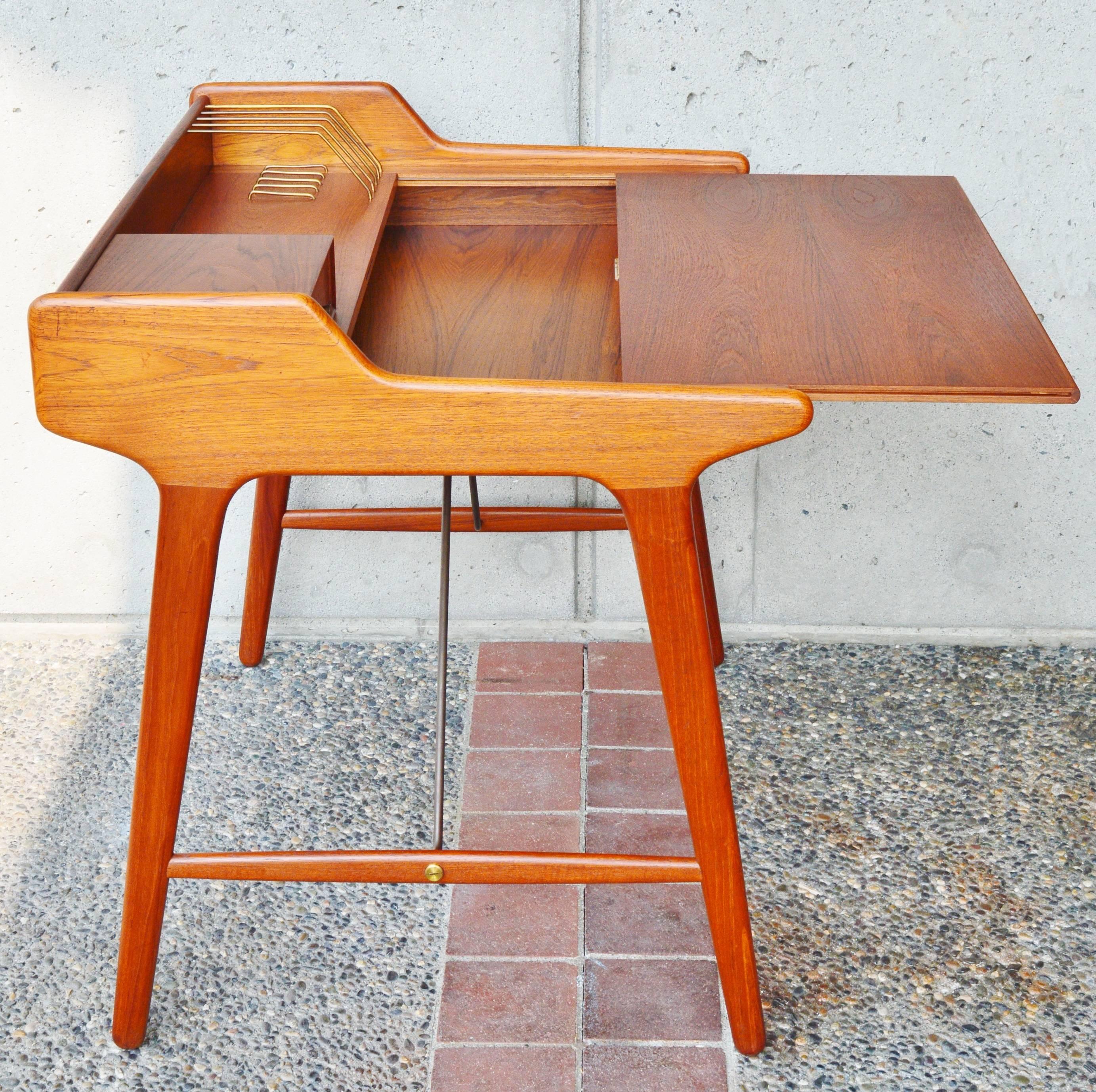 This iconic Danish modern Minimalist desk is a top quality design by acclaimed Danish architect and designer, Svend Madsen! Featuring all hardwood construction, the solid teak sides of the desk are beautifully sculpted and contour around the raised,