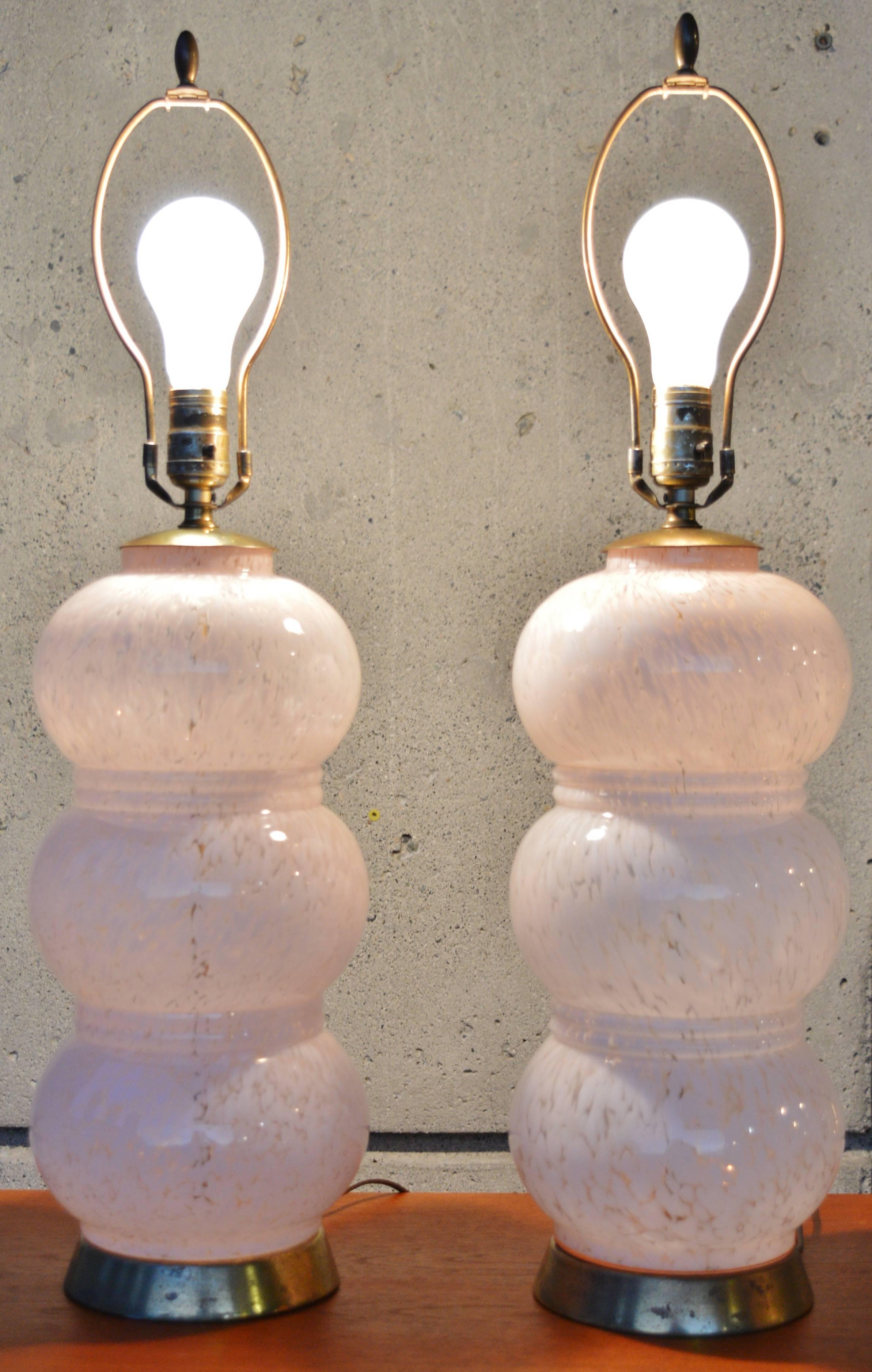 This striking pair of Murano stacked lamps are in the most lovely soft rose quartz hue mottled with clear the 2016 Pantone color of the year! Featuring three stacked balls that are each separated by a double band. The glass is in excellent