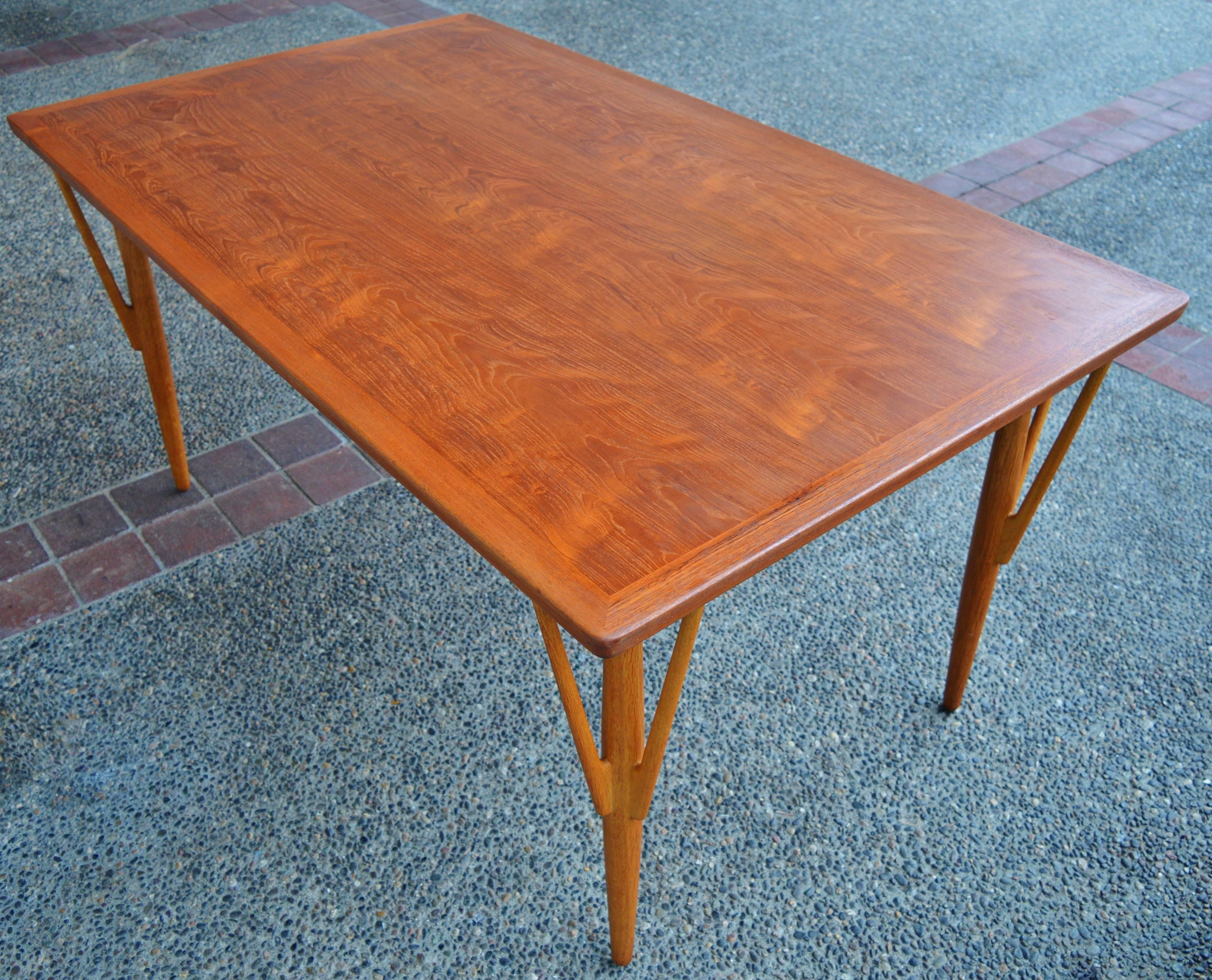 This absolutely stunning Danish Modern teak dining table was designed by Hans Wegner for Johannes Hansen and is branded with Hansen's mark. It was so remarkable a design, that Hansen showed it in his booth at the cabinetmakers' Guild Exhibition in