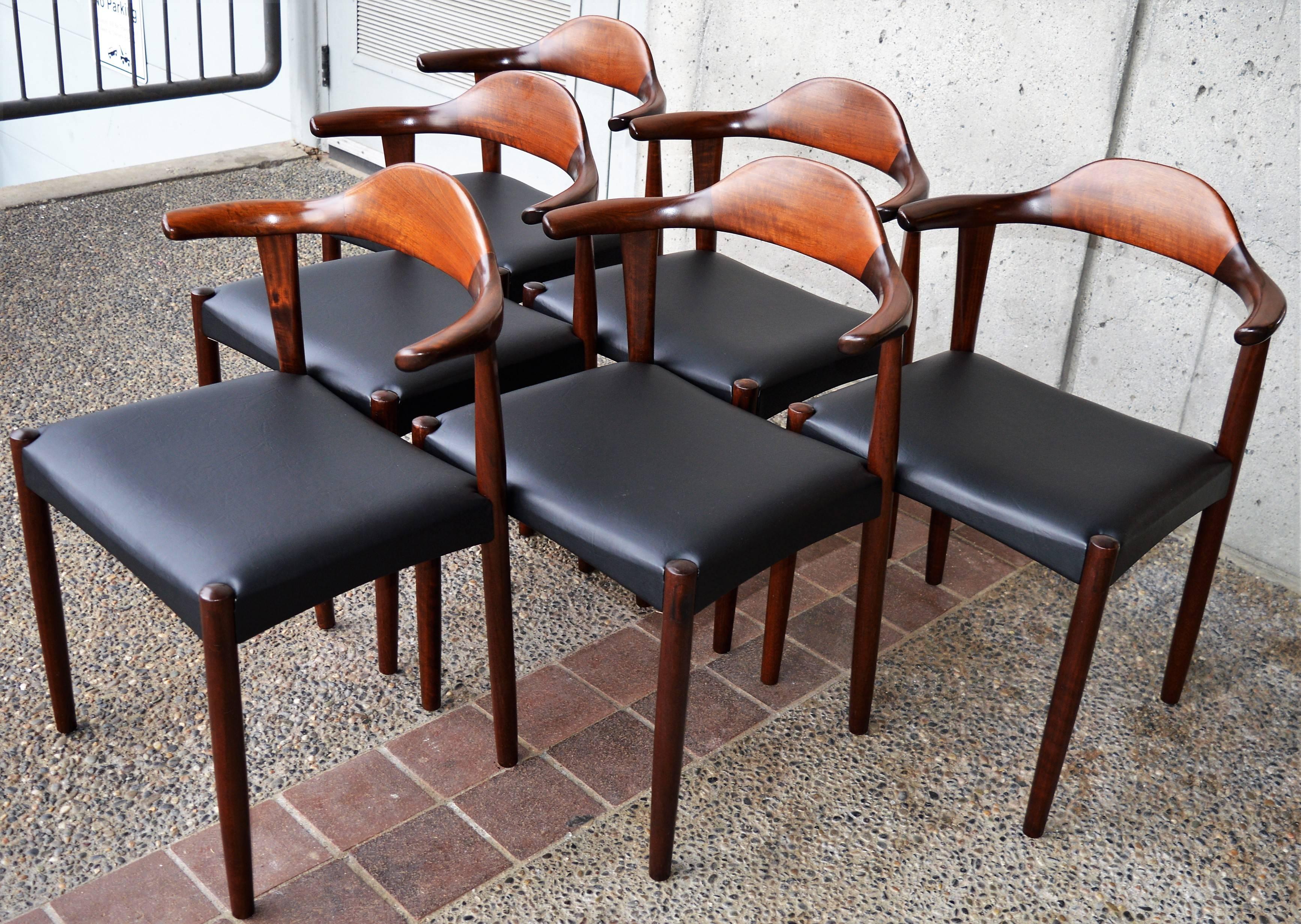 This spectacular set of six Danish Modern rosewood dining chairs with their iconic bull Horn armrests, were designed by Harry Ostergaard for Randers Mobelfabrik in the 1960s. These hand-sculpted chairs closely resemble the acclaimed Hans Wegner bull