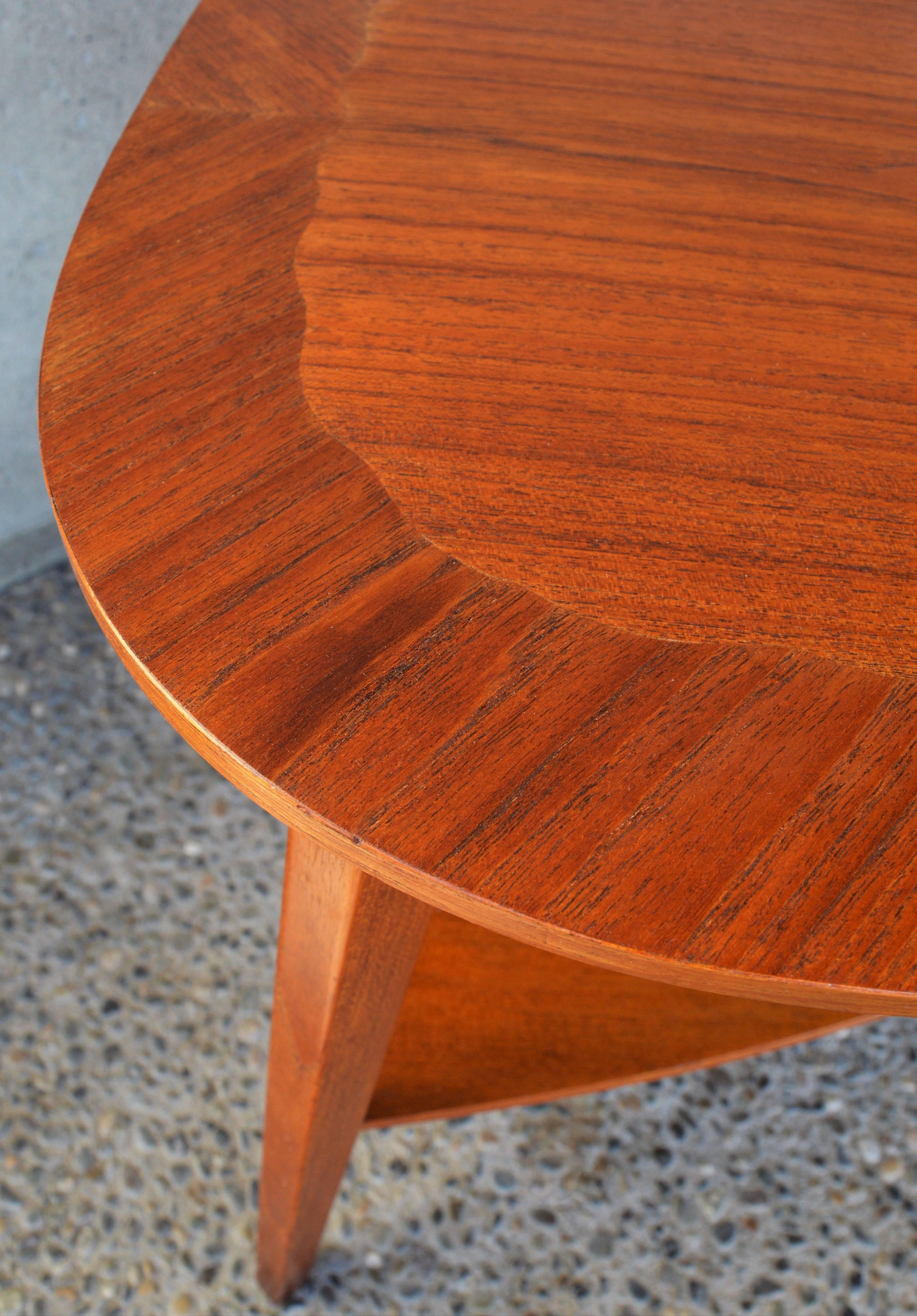 This super cute Danish Modern teak table has so many unique elements and is beautifully constructed. The organic shaped top makes it the perfect shape to place between two angled lounge chairs. The top has a very unique inlaid scalloped centre with