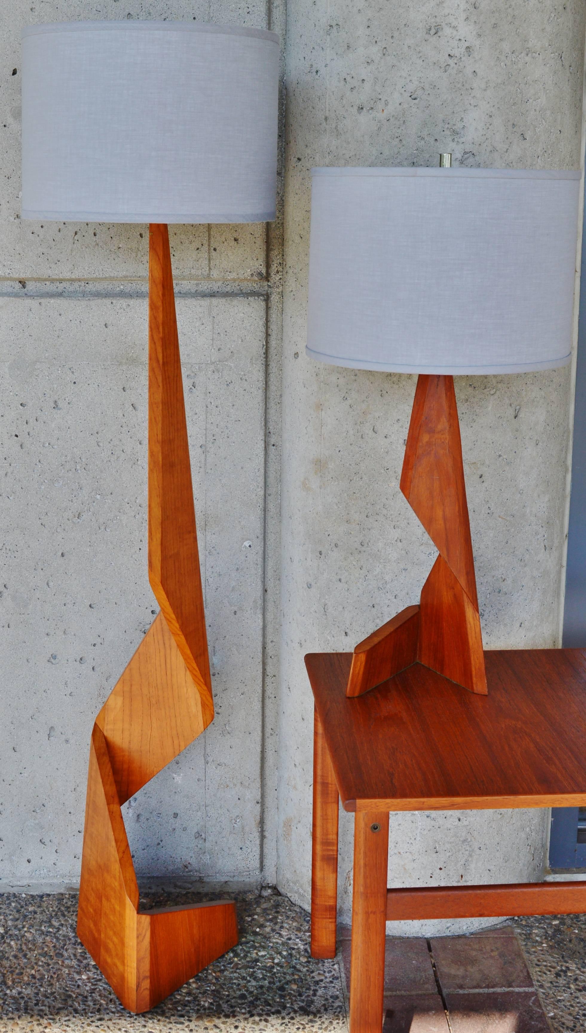So rare to have a set of two of these unique, architectural solid teak lamps! Featuring a stacked, faceted design with beveled edges that make for a very dramatic statement. Includes the harps and finials; the lampshades are not included but shown