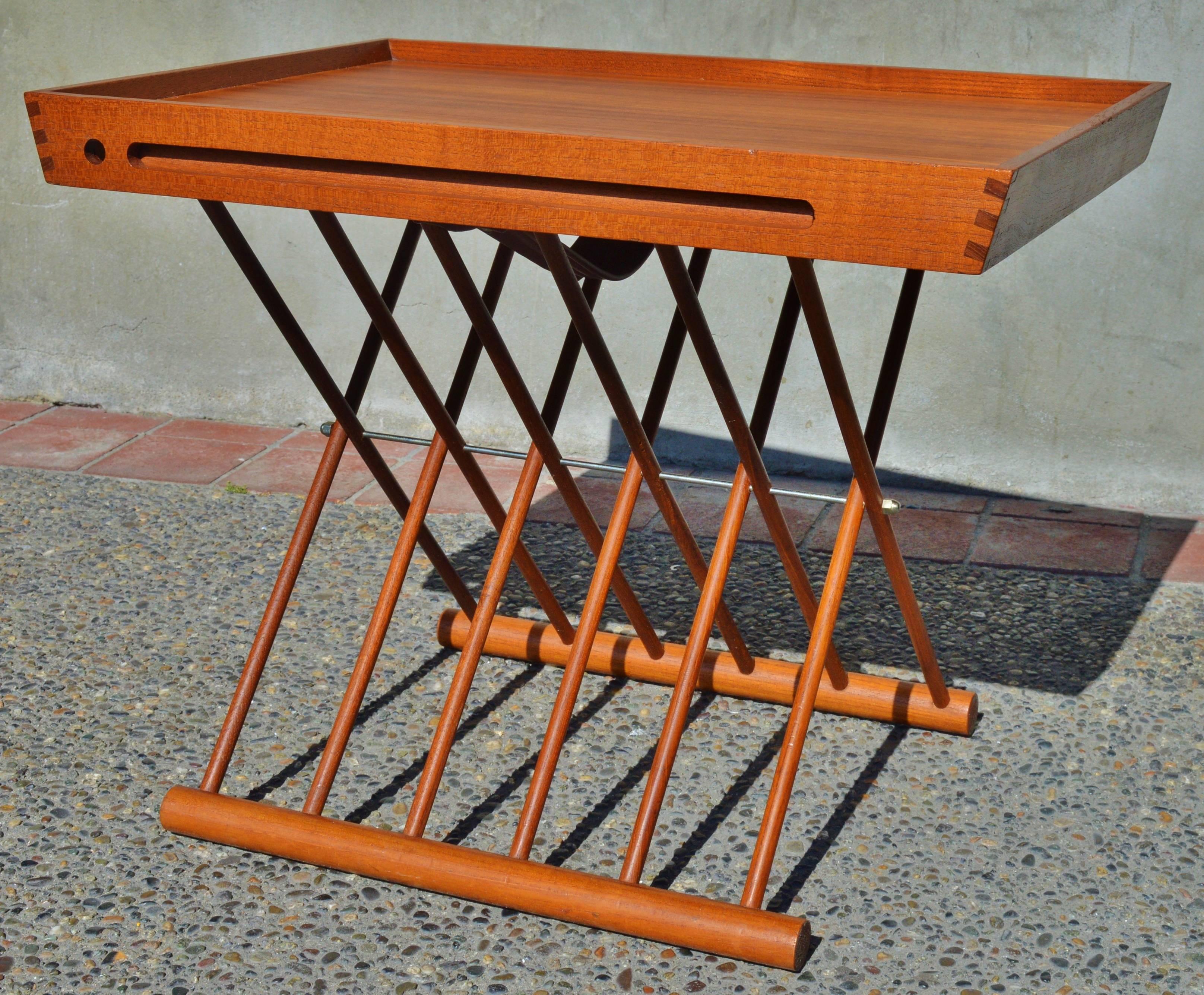 This unique Danish modern teak tray top folding table is a quality, early Danish piece bearing the branded Danish Control symbol. In excellent condition and just oiled, the table consists of a tray top upper which can be removed to serve guests,
