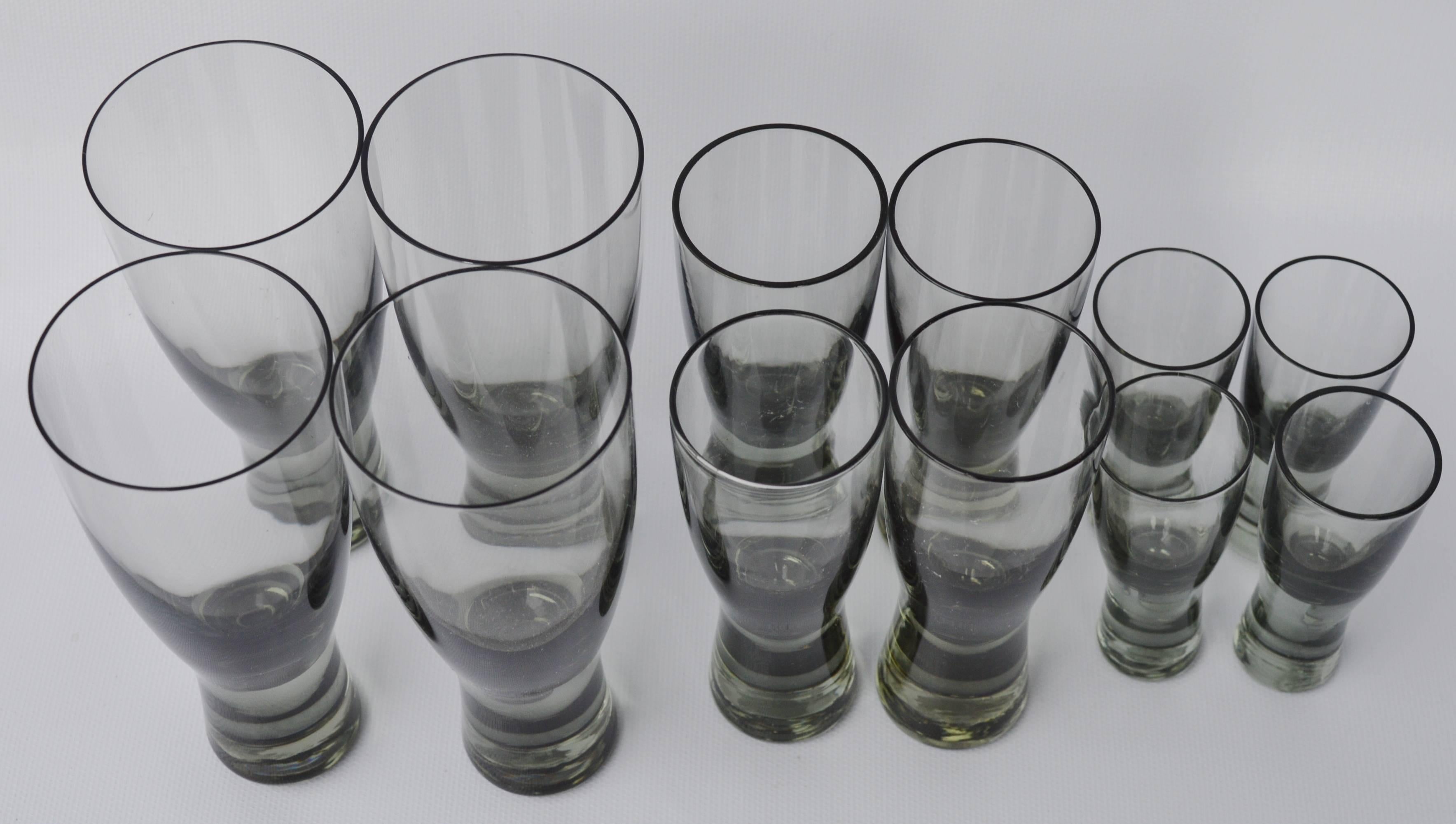 This delightful set of 12 per Lutkin smoked glasses for Holmegaard have a very pleasing shape. In perfect condition, the set consists of four each of the cordial, aperitif and wine glasses. The dimensions below are for the wine glasses. The aperitif