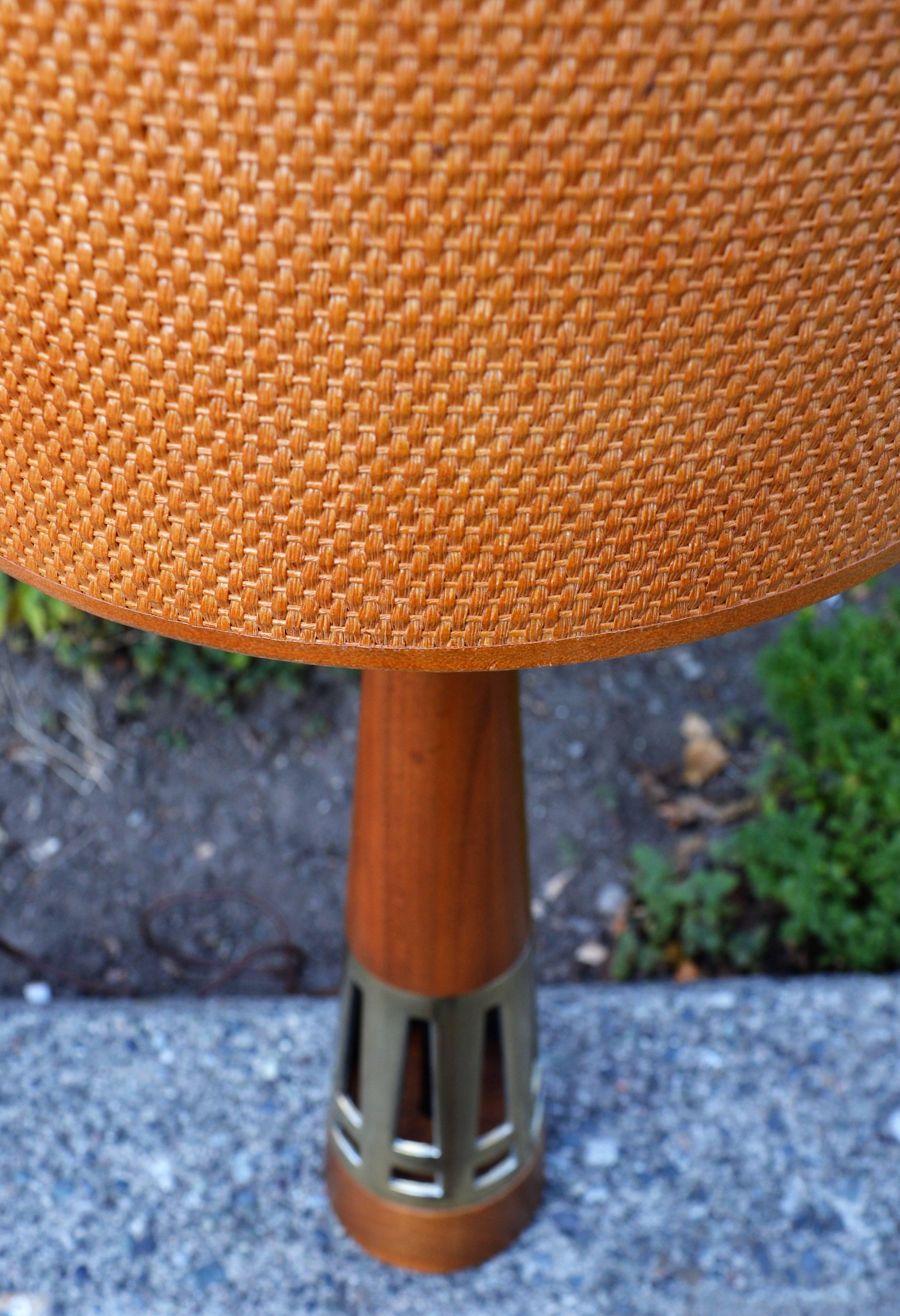 This striking Tony Paul for Westwood Industries conical walnut lamp with cast brass section has been perfectly paired with a basketweave grasscloth shade and a walnut finial. The brass is in excellent condition, the walnut has one or two very minor