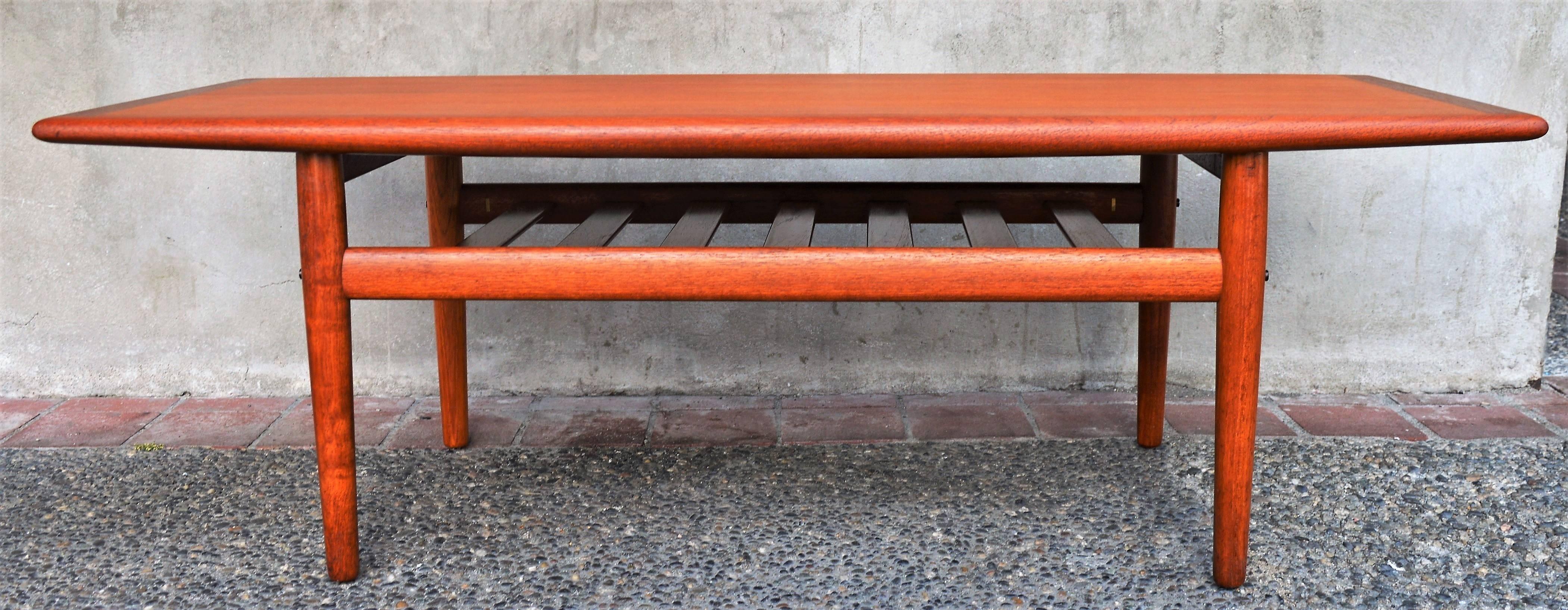 This gorgeous coffee table is the rarer smaller size and is in fantastic condition with a nice rich patina and lovely grain. Note the flared edges along the sides of the top of the table - in this version of the table, they flare downwards. Designed