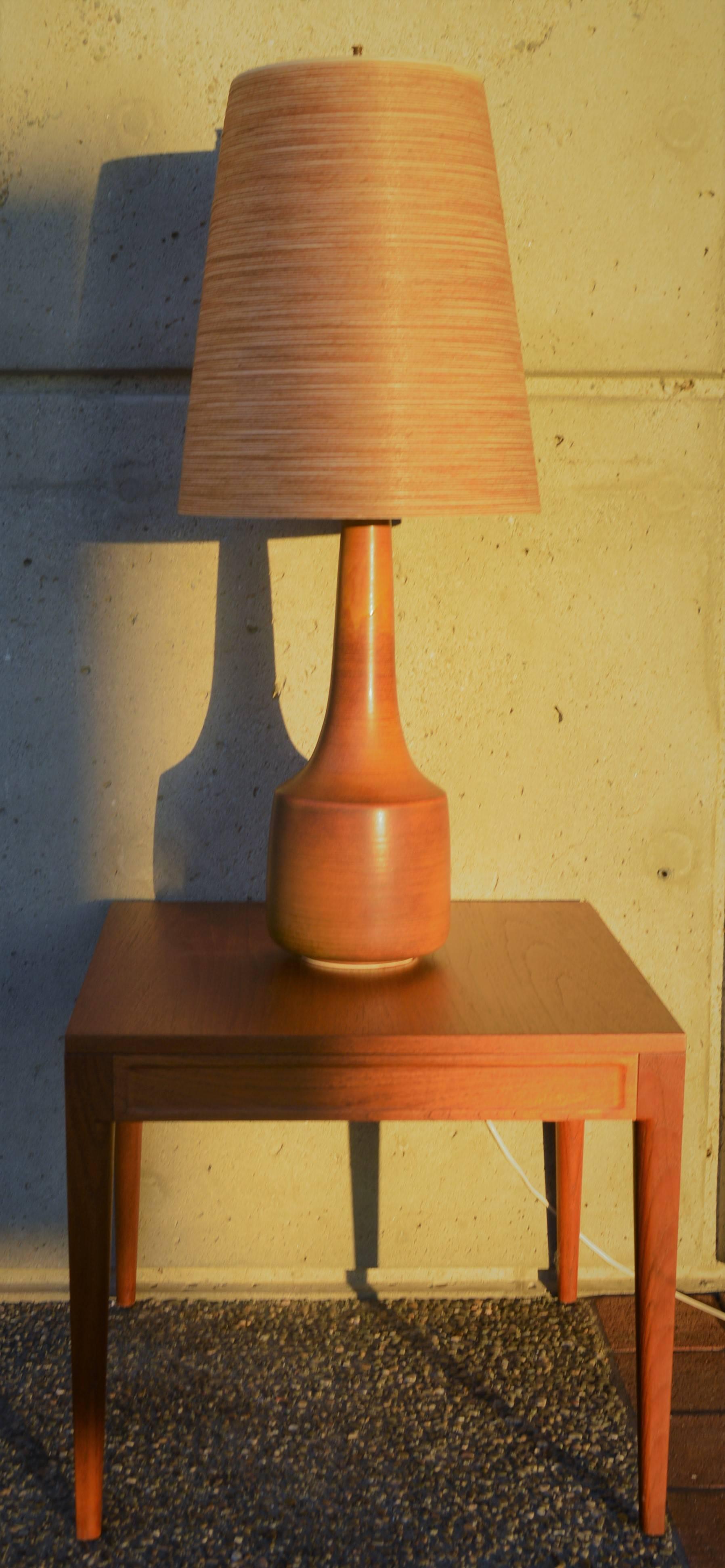 This early and stunning tall ceramic cylinder lamp was handcrafted in the 1960s by Danish potters Lotte & Gunnar Bostlund. The subtle glazing variations and striping of the brown and caramel earth tones is spectacular. Featuring their uniquely