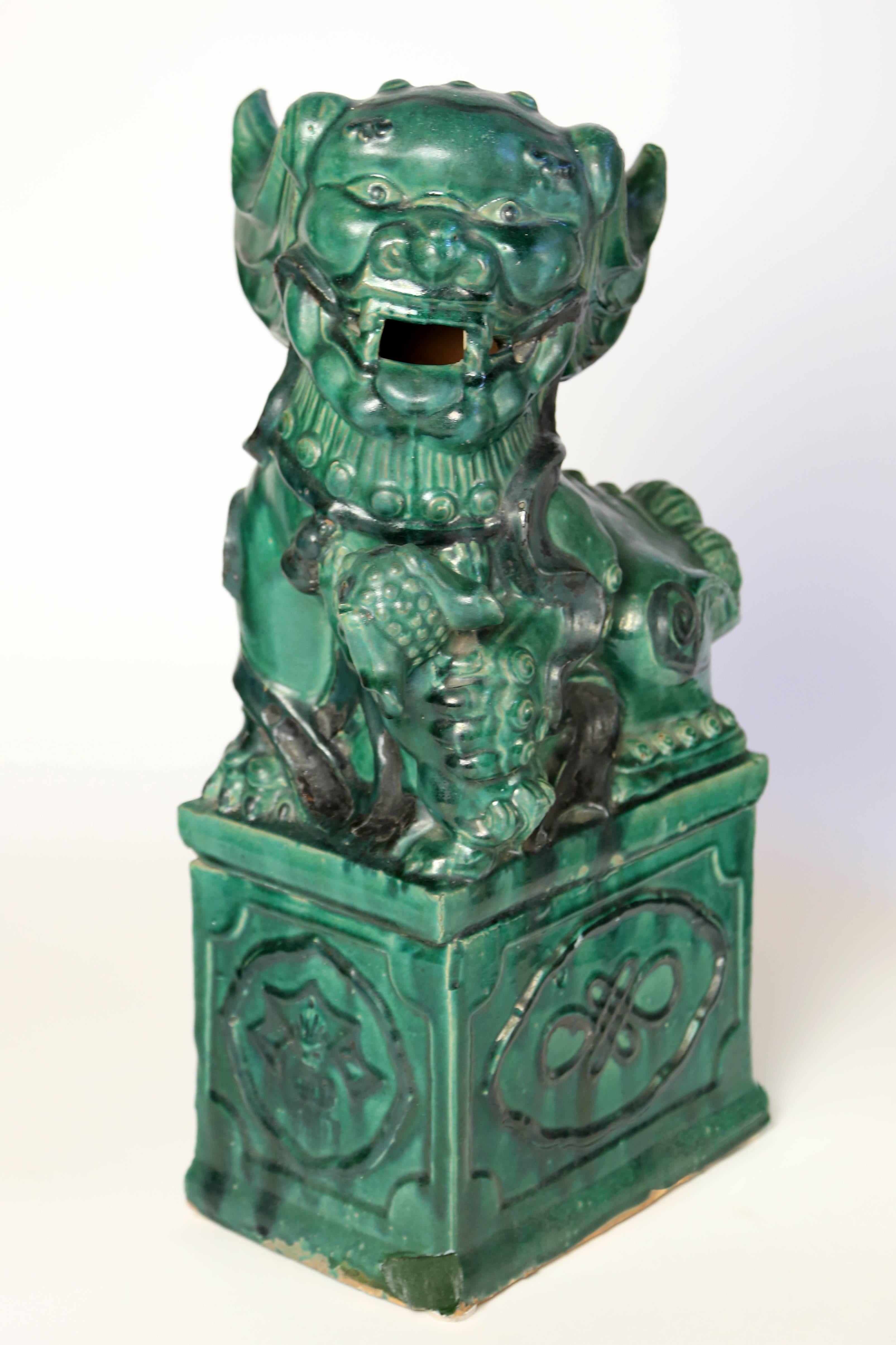 Antique Chinese ceramic figural sculpture, modeled as a foo lion and cub with green glaze, standing on conjoined pedestal, minor glaze loss along base.