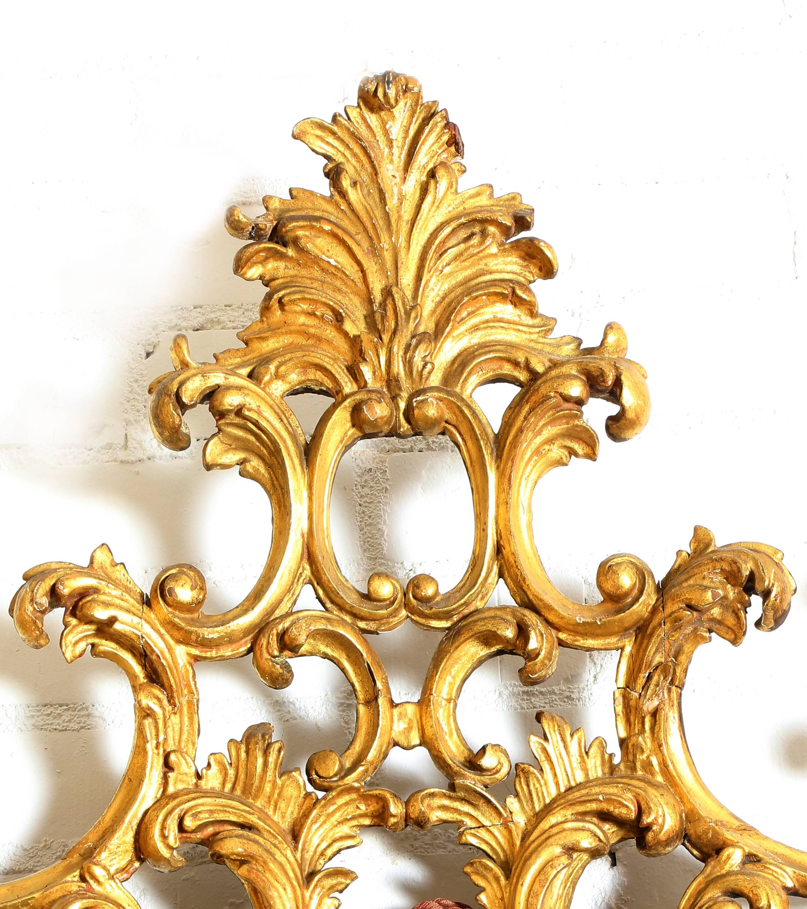 Talian gilt Louis XV style wall mirror, 20th century, the ornate pierced foliate crest and frame with single scrolling band crossing the shaped mirror plate.
 