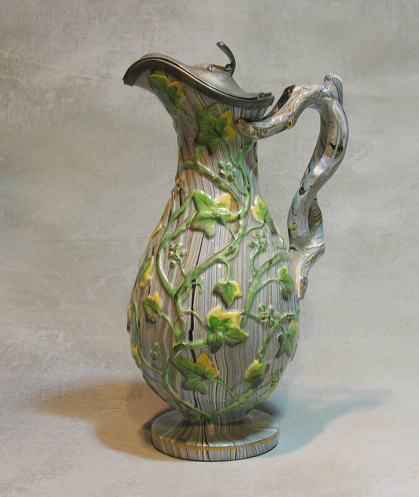 Rare Staffordshire agateware pitcher with pewter lid, circa 1840. Baluster shaped body molded overall, with vinery in greens and yellows on a blue beige and grey marbleized background, gilt decorated twig form handle, pewter lid stamped inside lid