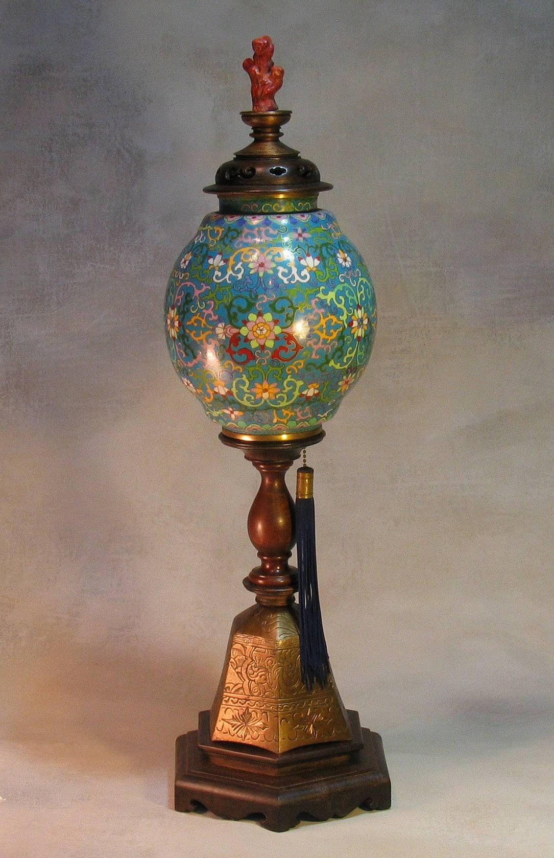 Chines lamp with a plique-a-jour shade, circa 1900. Ovid shaped plique-a jour cloisonné shade with pierced wood cover and imitation carved coral finial on a wood turned baluster stem and hexagonal bronze Buddhist bell incised with writhing dragon,