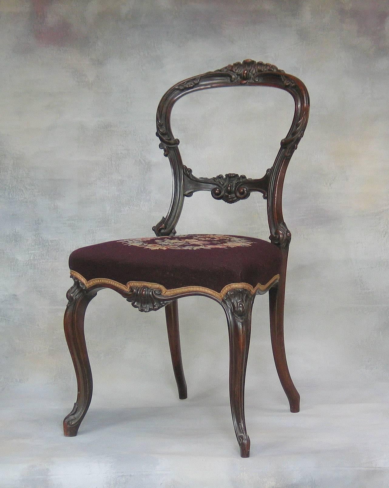 A mid-Victorian Rocco Revival rosewood side chair with needlepoint upholstery, finely carved and elegant proportions and in fine condition, circa 1860. The side chair measures 35"-inches high x 19"-inches wide x 20"-inches deep, the