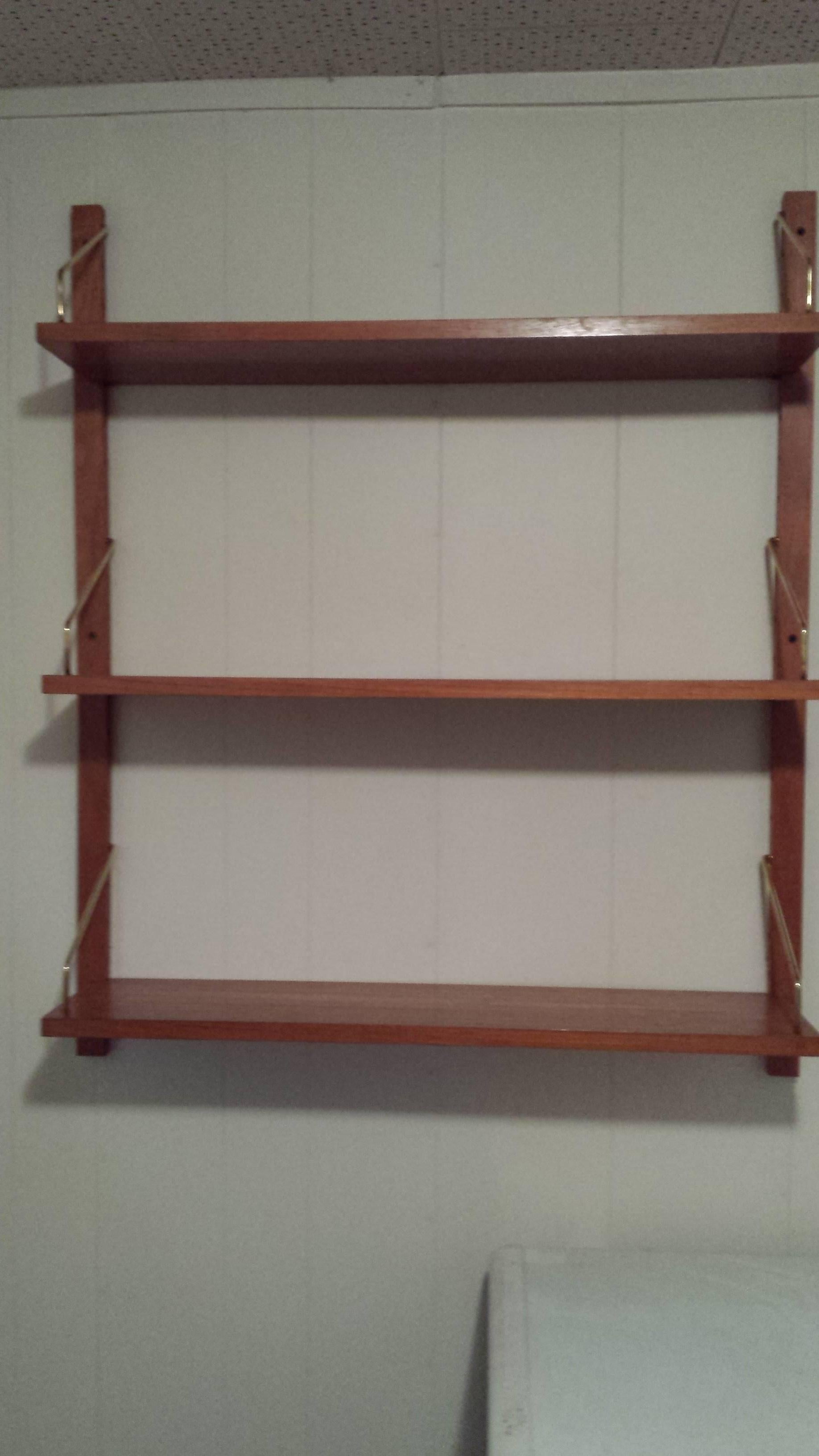 Mid Century Danish Solid Teak Adjustable 3-Shelf Wall Unit, Made in Denmark, Brass Shelf support brackets and shelf pins, 2-Support Brackets to mount on the wall, easy assembly. The shelf measures 39