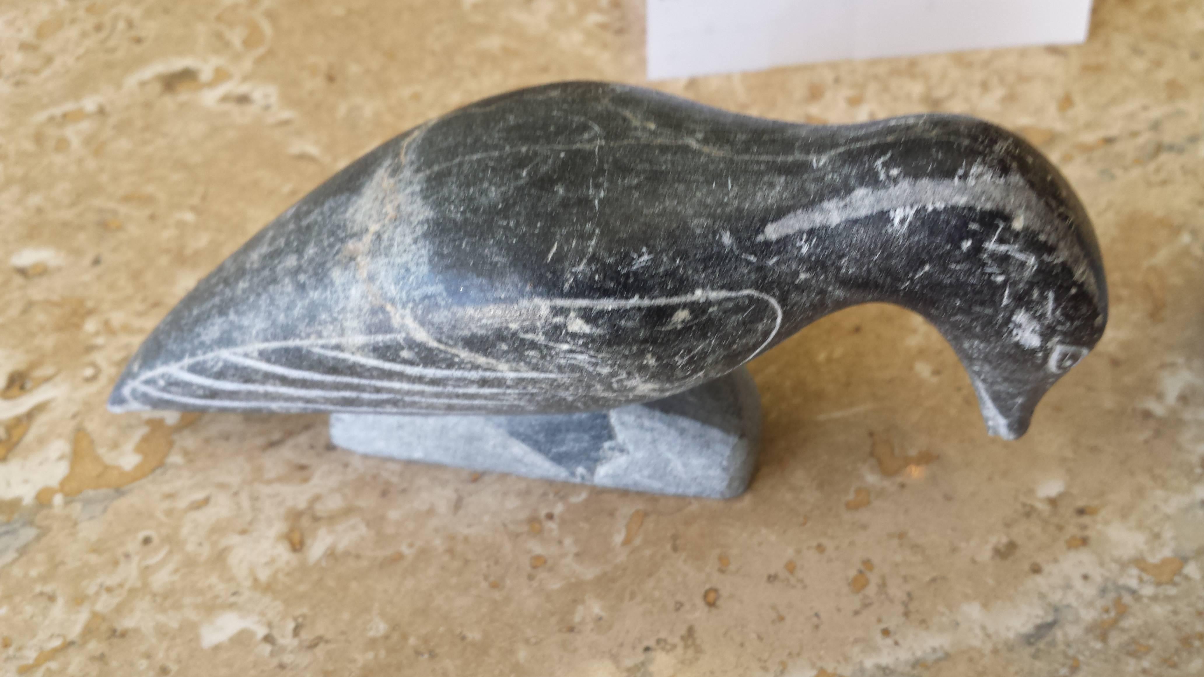 Pair of soapstone Inuit birds signed in Syllabics and E numbered for Carver ID. Both are carved in black colored soapstone, the bird with his beak down measures 5" inches long x 1 1/2" inches deep x 2 1/2" inches high. (Please see