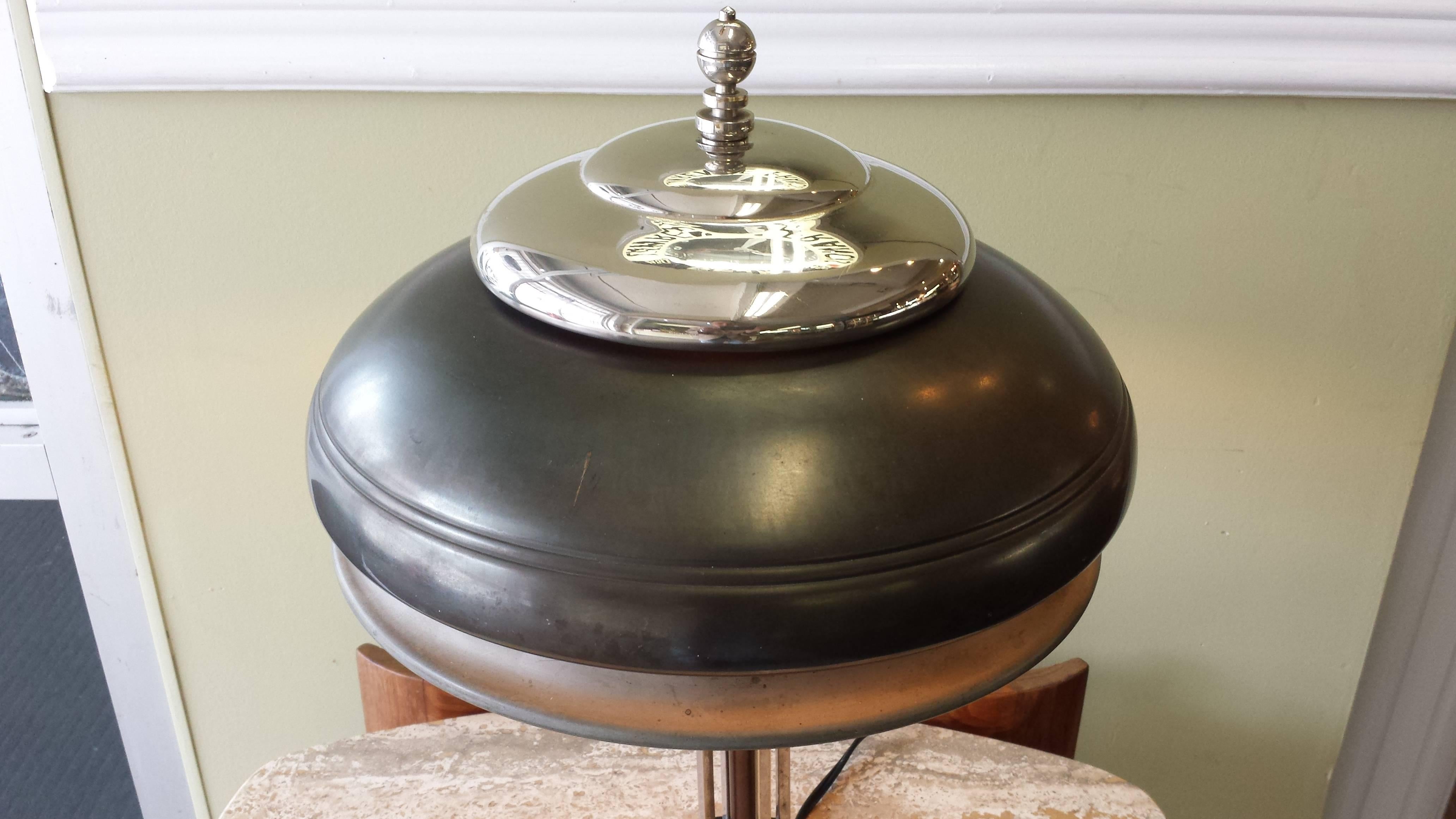 Vintage Markel Machine Age Art Deco table lamp, circa 1930s, the lamp has a three-tier metal shade and signature Markel finial. The base is a tube column and round disc, with black accent details. The lamp is in working condition, the lamp is