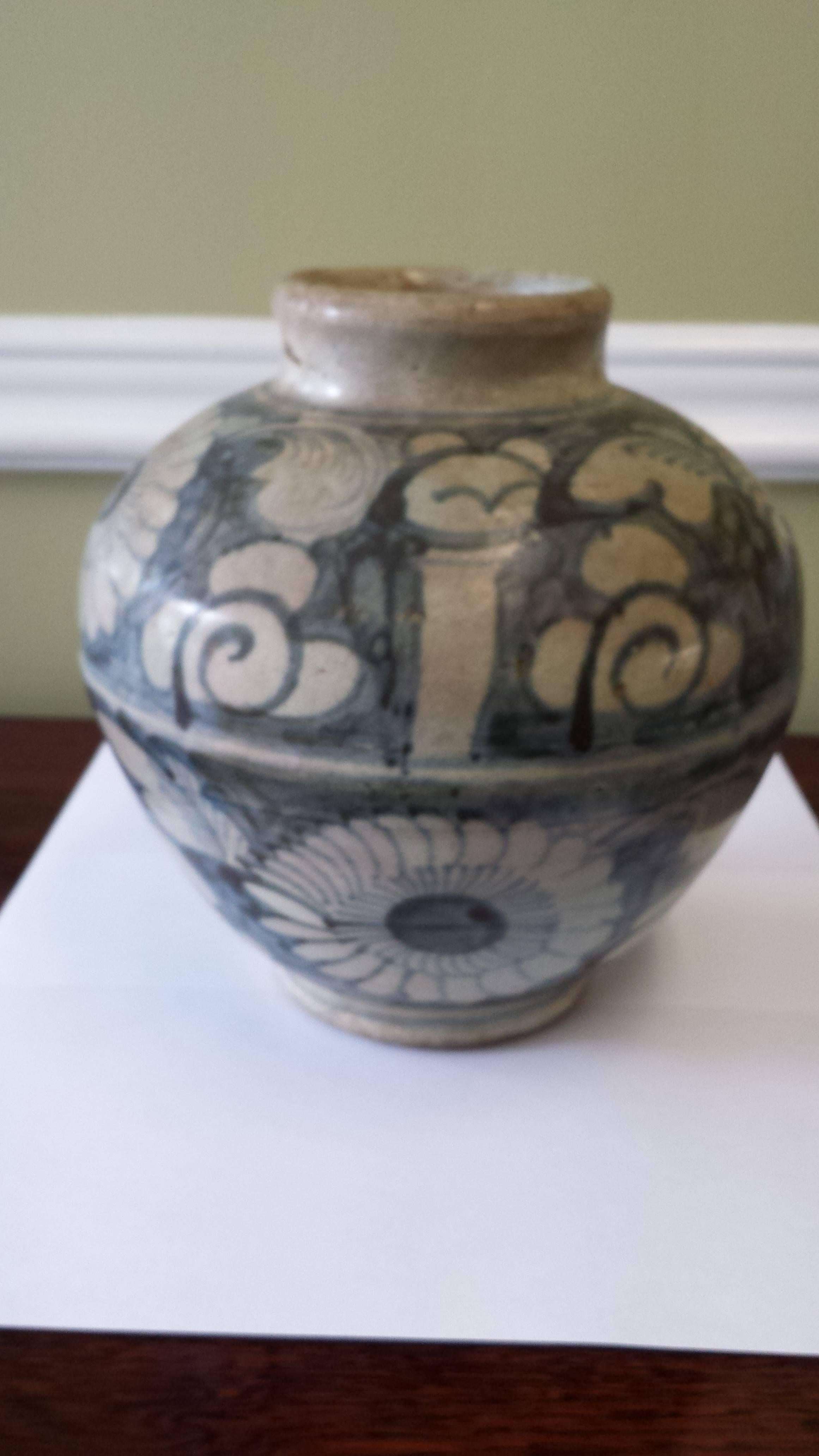 A Chinese Zhangzhou (Swatow) storage jar/gun powder jar, late Ming or early Qing dynasty, ovoid shaped storage jar on low footing with a short neck painted in underglaze blue with bands of flower heads and scrolling foliate tendrils, glaze is