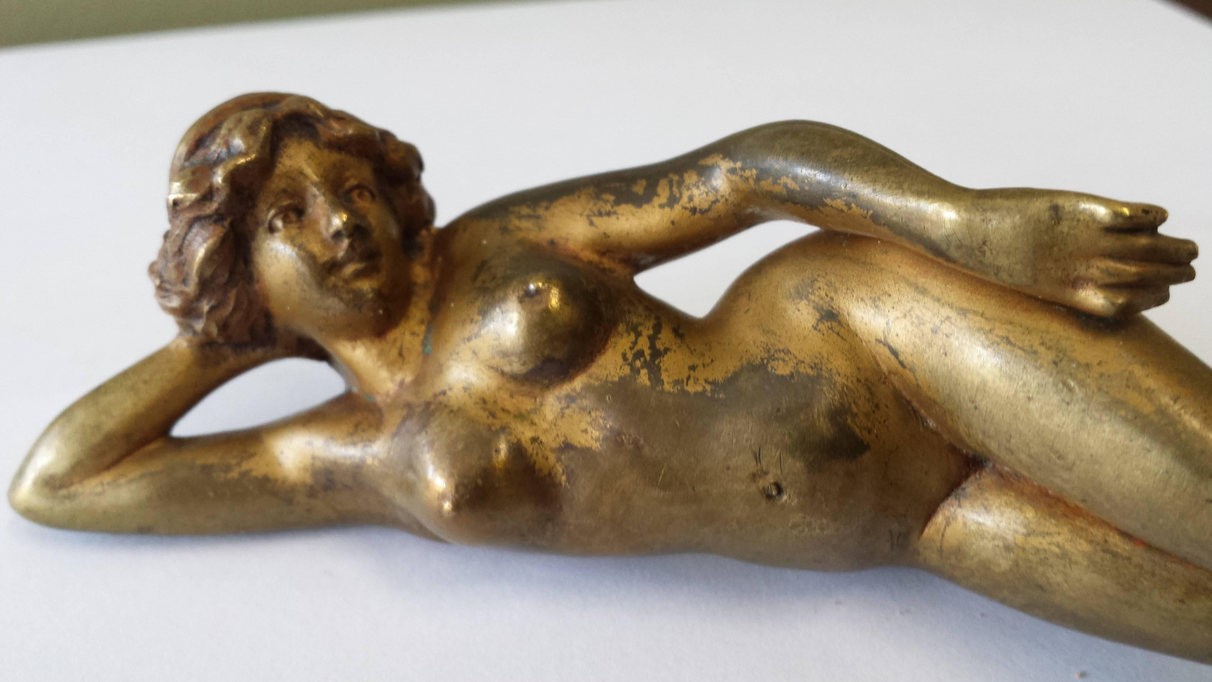 French gilt bronze figure of a reclining nude early 20th century, finally cast figure resting on her side. Gilt finish is worn, but retaining a nice color and patina. The figure is of very nice quality and stunning. The figure is circa 1900.
The