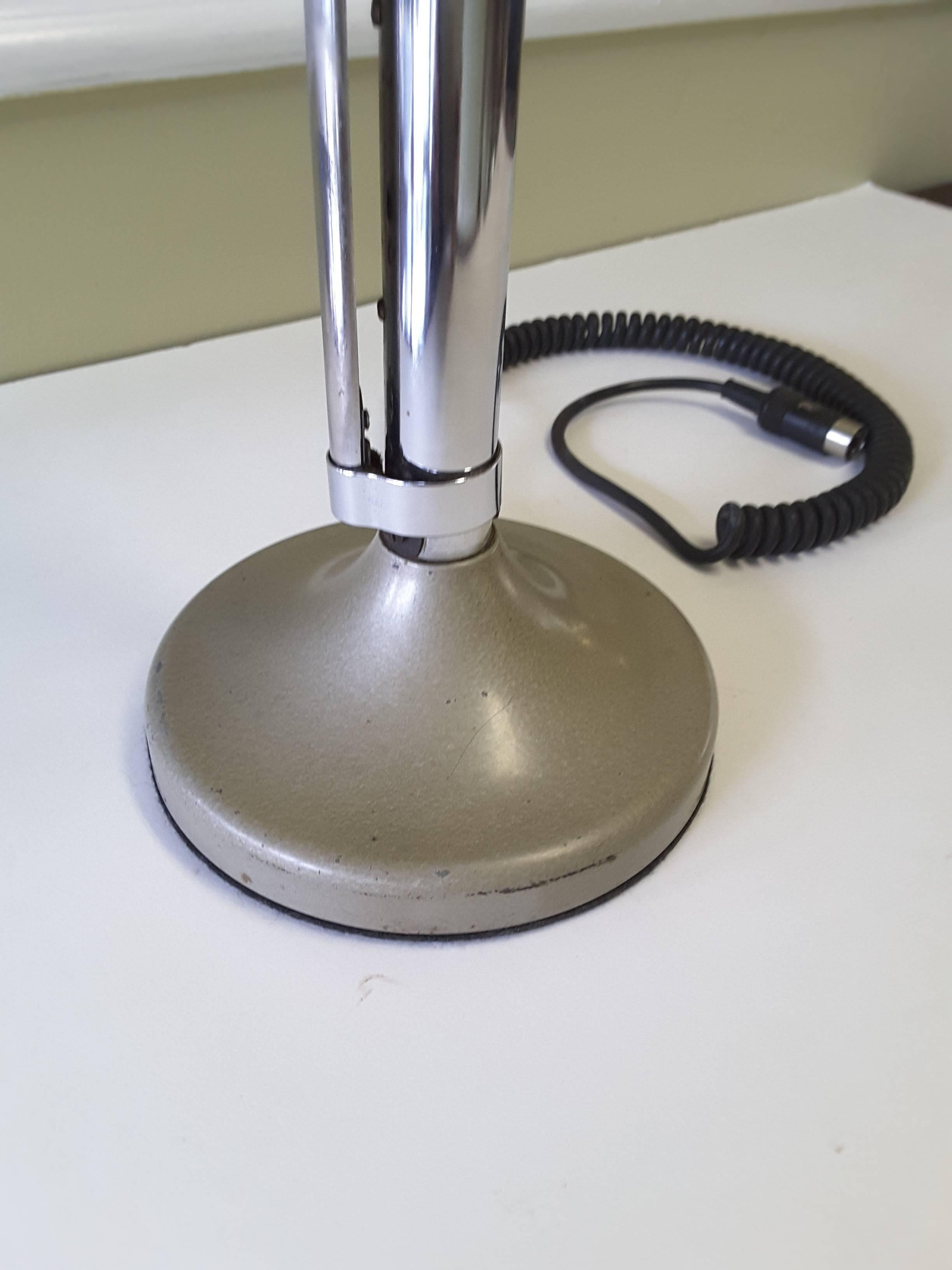 Mid-Century Modern chrome tabletop microphone by Astatic Ltd. Made in Toronto, Canada. Round mouth piece with a screen cover and a push bar side talk switch, the mic has a five-pin plug on a black coiled wire. The microphone measures 12"-inches