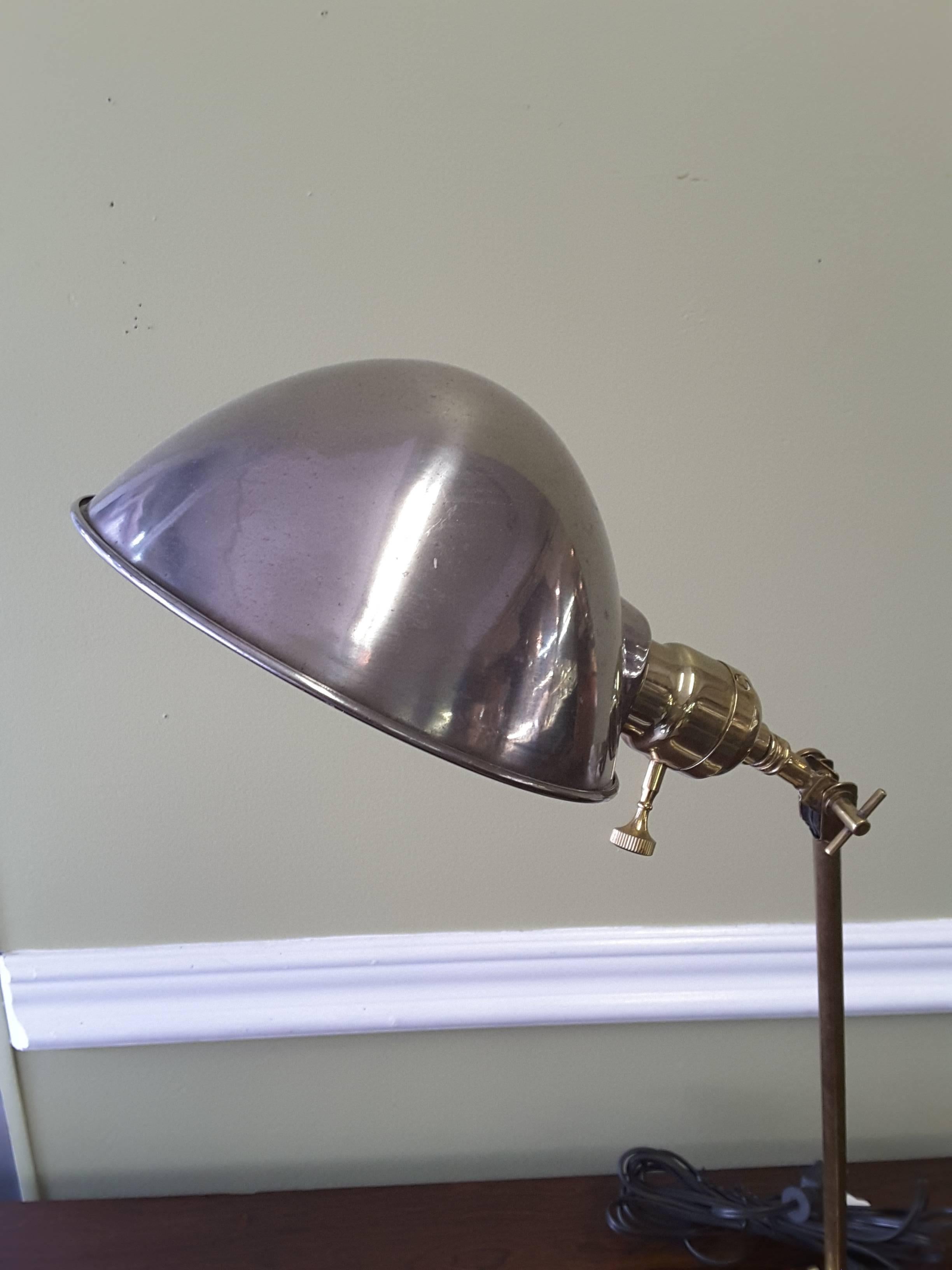 Faries Industrial brass adjustable desk lamp with polished steel shade, circa 1920. An adjustable desk lamp popularized by Faries. The lamp has newer replaced wire and plug a high polished steel lamp shade and is adjustable to multiple positions.