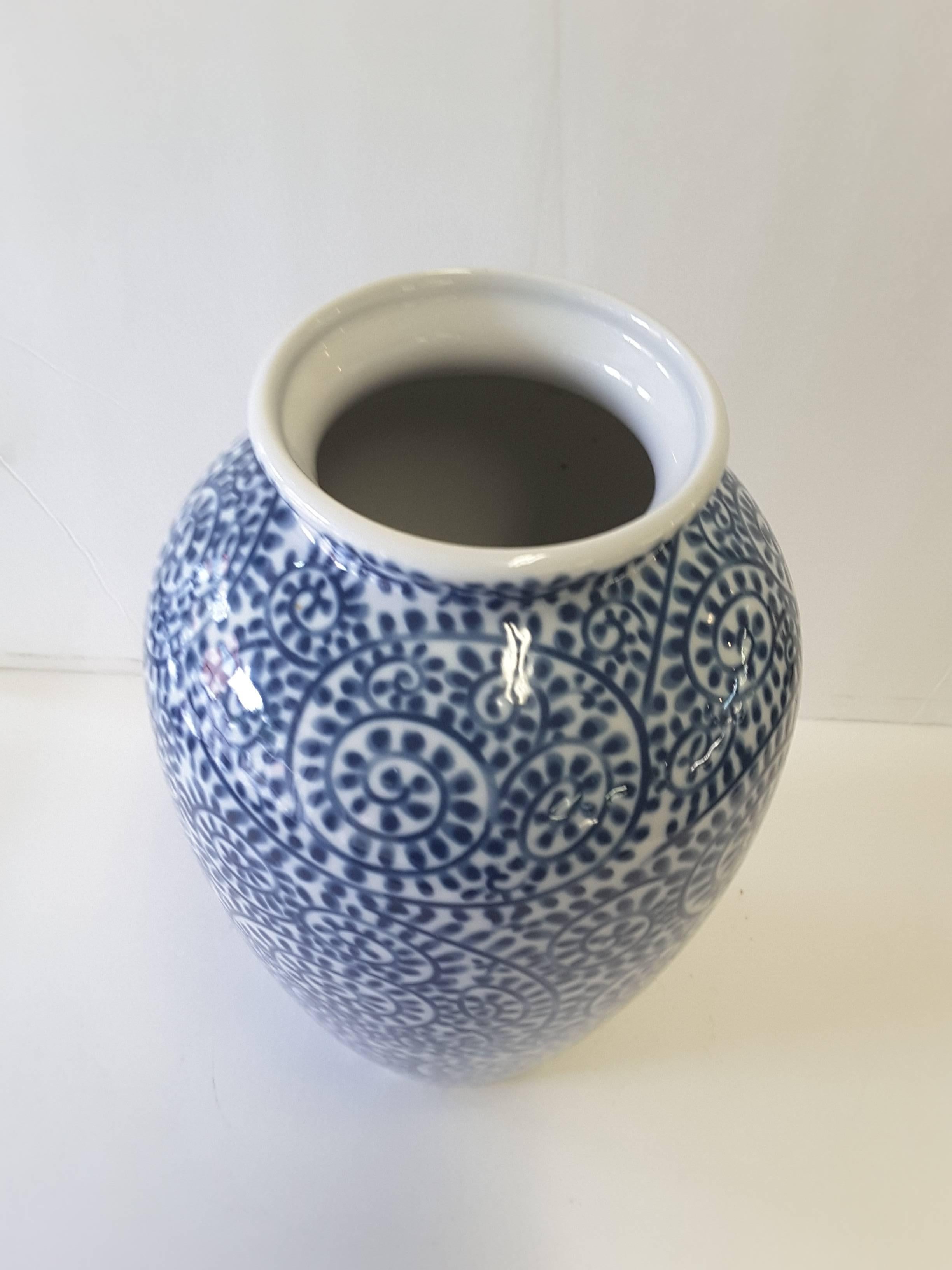 A Japanese blue and white porcelain hand decorated vase, "Tako Karakusa" pattern in underglaze, from Ryuho Kiln, (modern, late 20th century). The vase measures 10" inches high x 4 1/2" inches in diameter.
