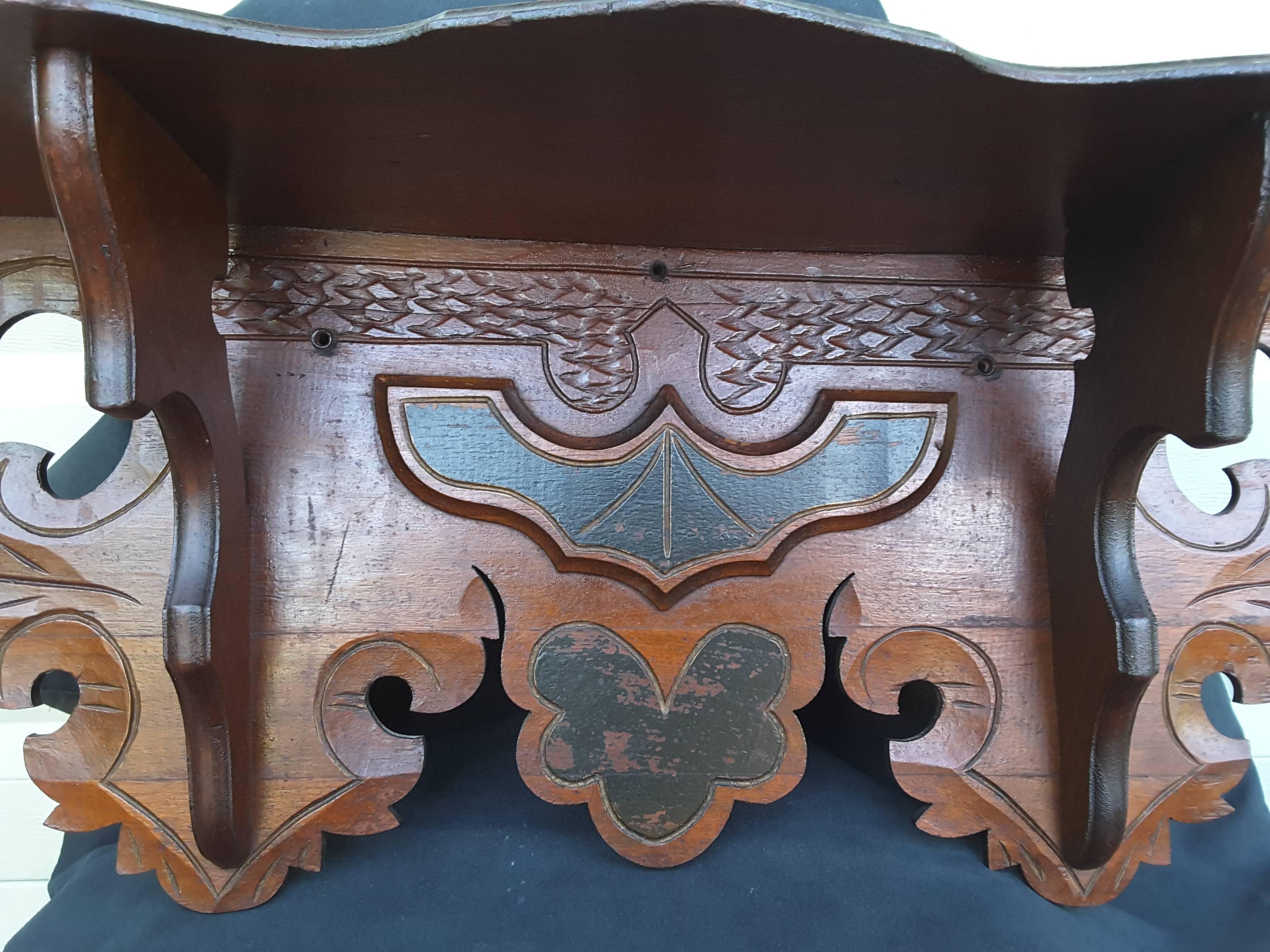 Edwardian solid walnut carved wall shelf, clock shelf with black accented highlights, circa 1910, nicely carved leaf pattern, scalloped edges, with two detailed upper shelf supports. The shelf measures 27 1/4"-inches wide x 10"-inches high