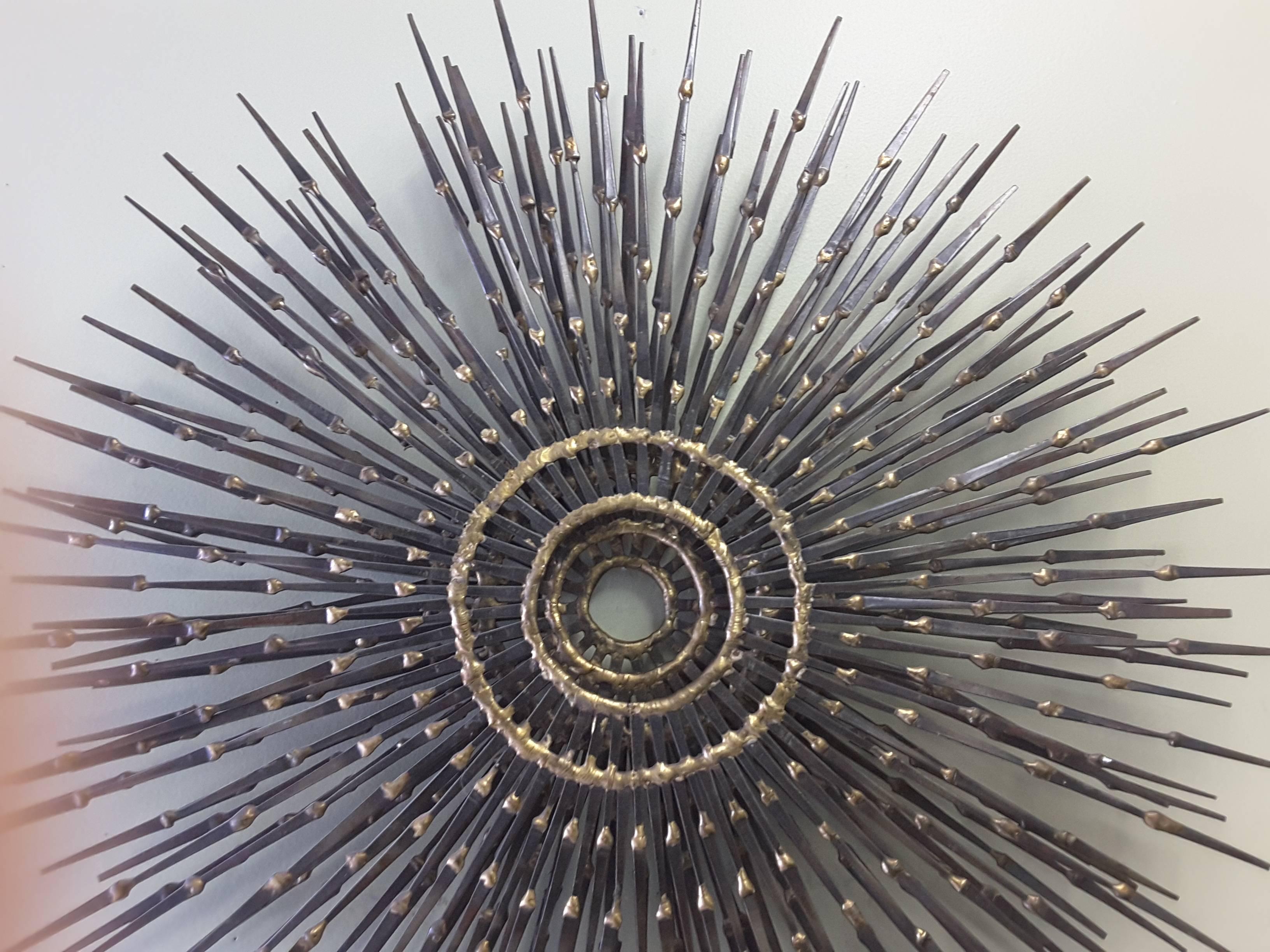 A three ring shrinking concentric circle wall sculpture circa 1960, in the manner of Curtis Jere, made with flat horseshoe nails and brazed (welded) together, back hanging mounts. The sculpture measures a large 24 1/2