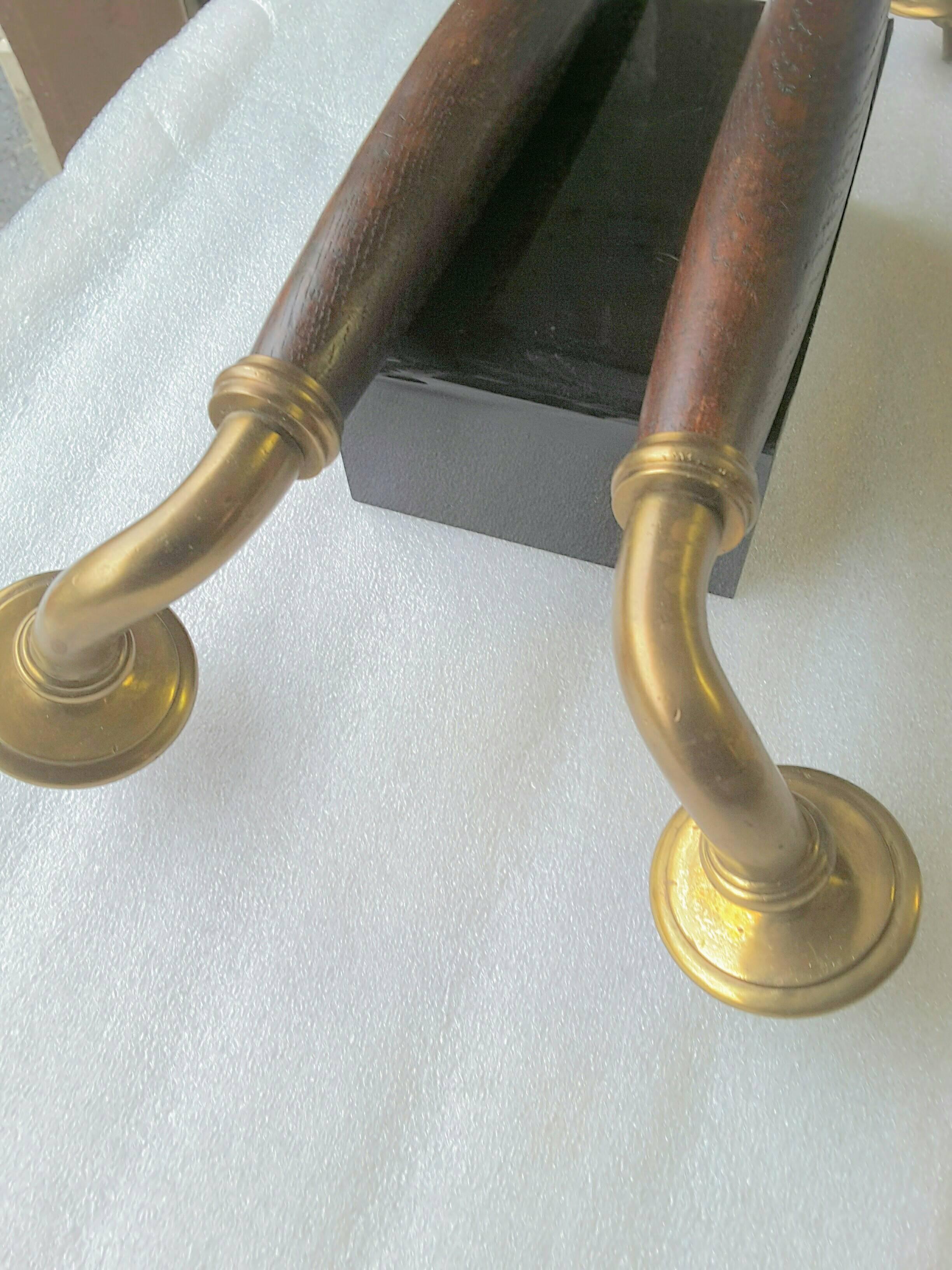 A pair of English brass and dark oak full size door pulls/handles, circa 1910, the handles are made of solid brass including the back nuts for attachment, the center for hand placement is made in solid English oak. The pulls were more likely for a