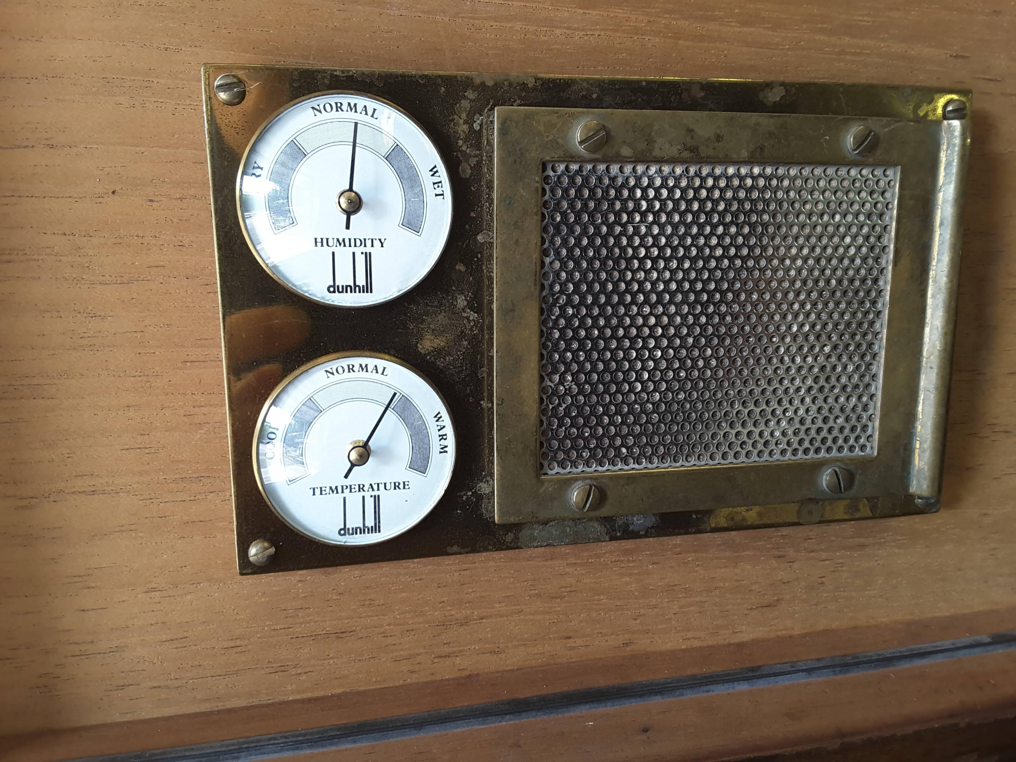 A Dunhill cigar humidor with a brass temperature and humidity gauge with removable moisture pad on the lid. The case is in burl walnut and has a key and working lock. The box measures 13 3/4