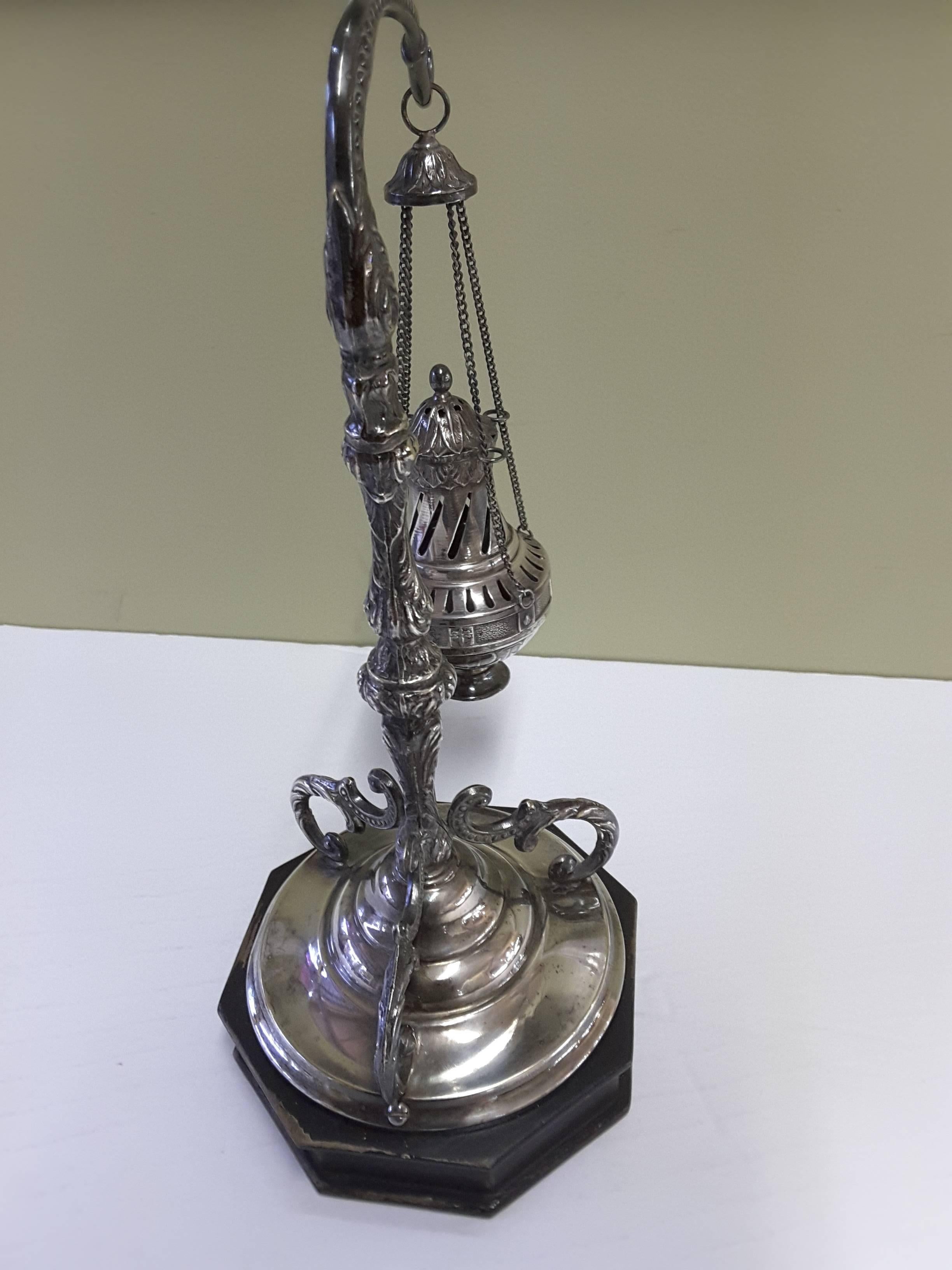A fine antique Spanish silver Thurible (Censer), circa 1900, done in continental silver 800-850, mounted on an ebonized octagonal base. A swing four chain censor hangs from the decorated arm and mounts to the base.
A small scale replica of a