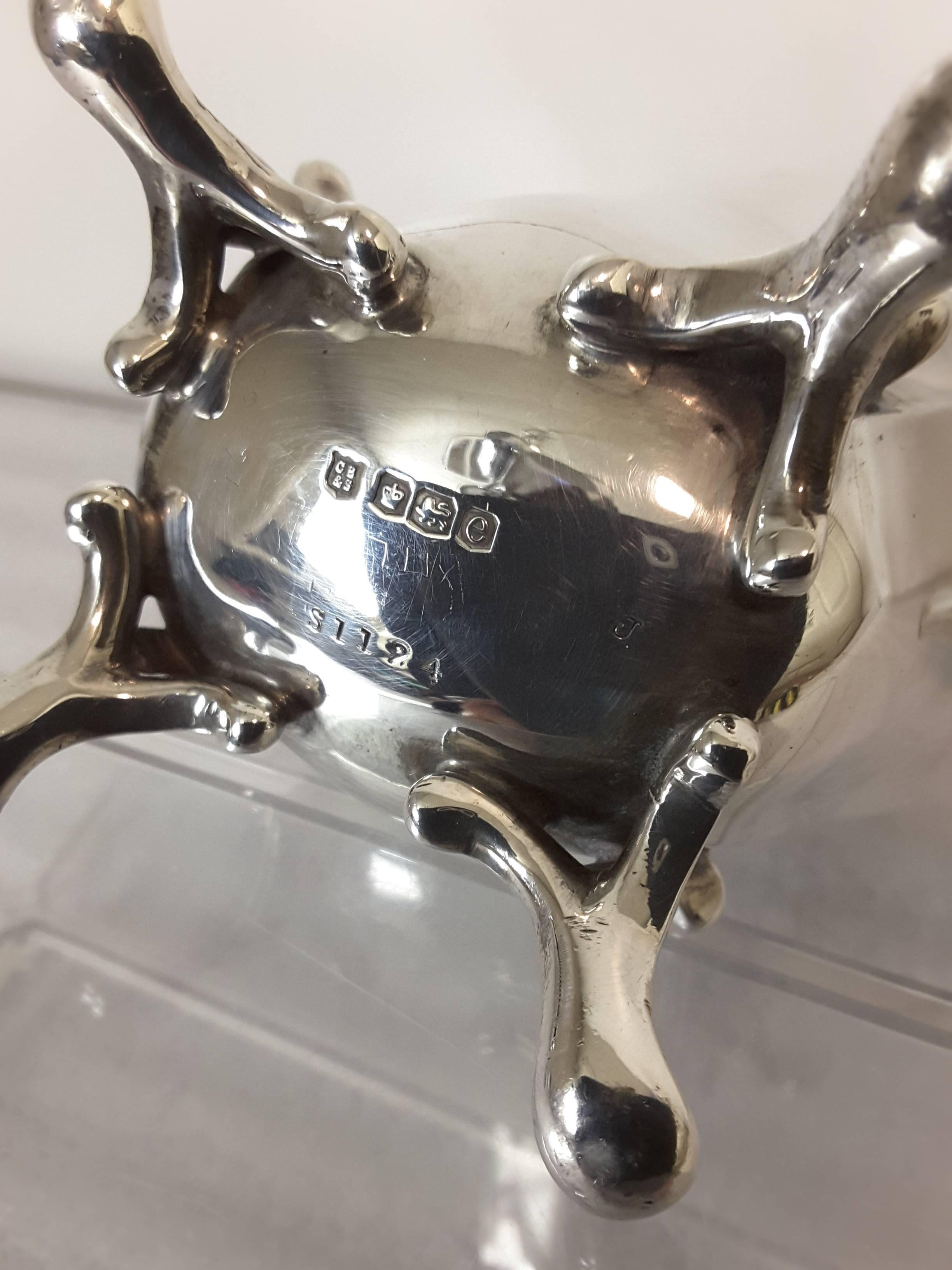 Sterling silver tea pot by Charles Boyton & Son, London, Hallmarked for 1900, Slender tapered body on a raised scroll foot. The body is decorated with laurel motifs and vines with heat spacers on the handle and on the lid. Fully marked on the bottom